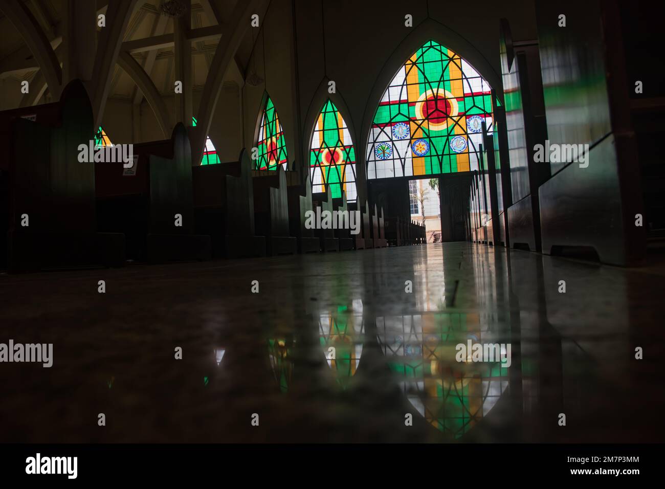 Innenraum mit bunten religiösen Motiven auf Buntglasfenstern in der katholischen Kirche in Abuja, die Kirche ist als nationales christliches Zentrum bekannt Stockfoto