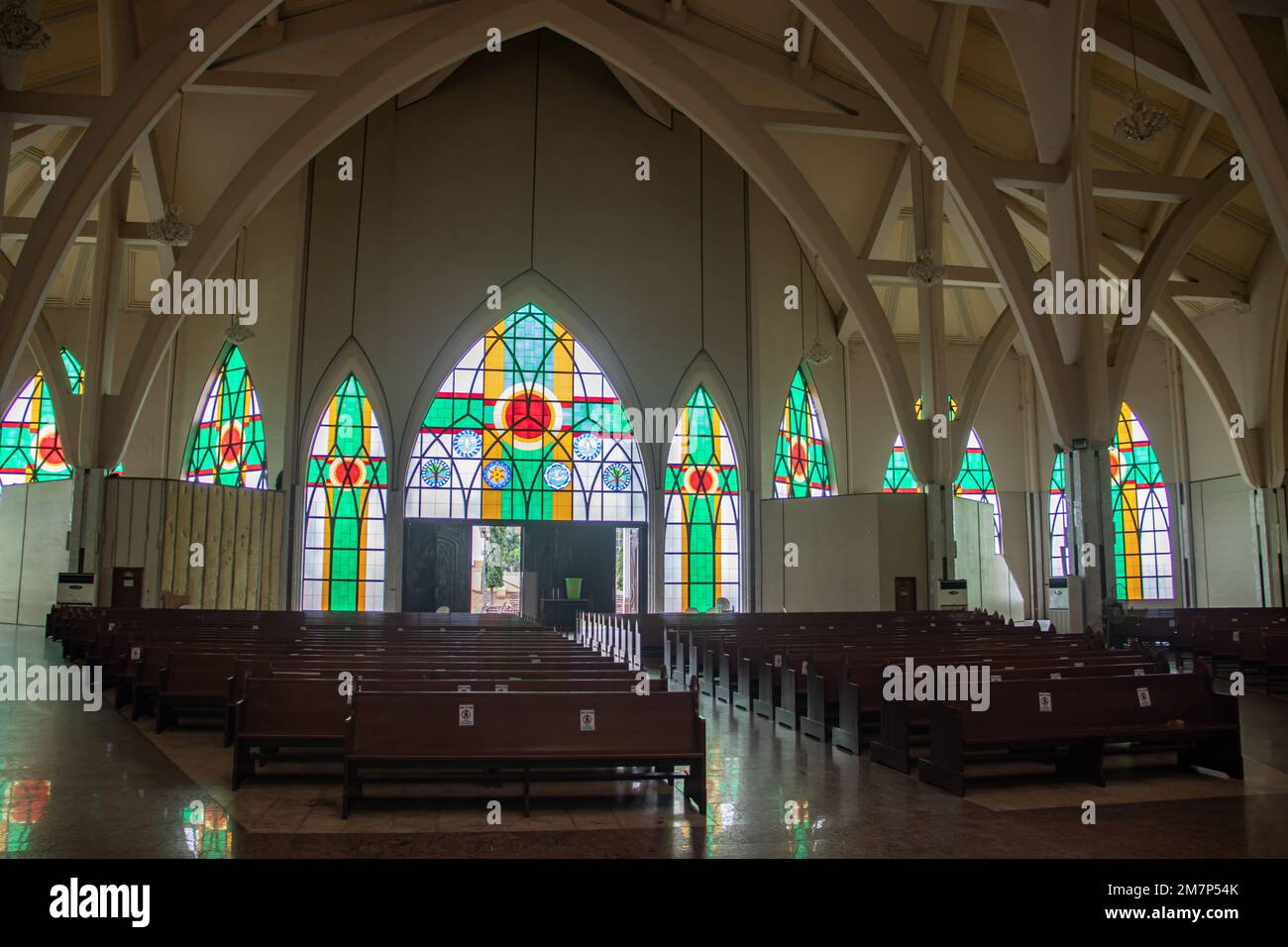 Das Innere mit Bögen, Kreuzen und Buntglasfenstern in der katholischen Kirche in Abuja, Nigeria, ist als National Christian Centre bekannt Stockfoto
