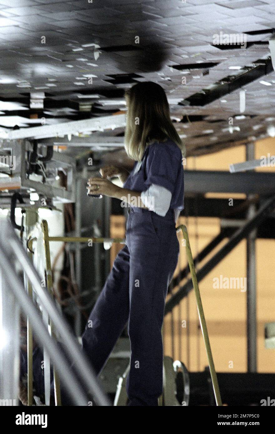 Ein Mitarbeiter im Kennedy Space Center sichert Ziegel auf dem Space Shuttle Columbia. Basis: Cape Canaveral Bundesstaat: Florida (FL) Land: Vereinigte Staaten von Amerika (USA) Stockfoto