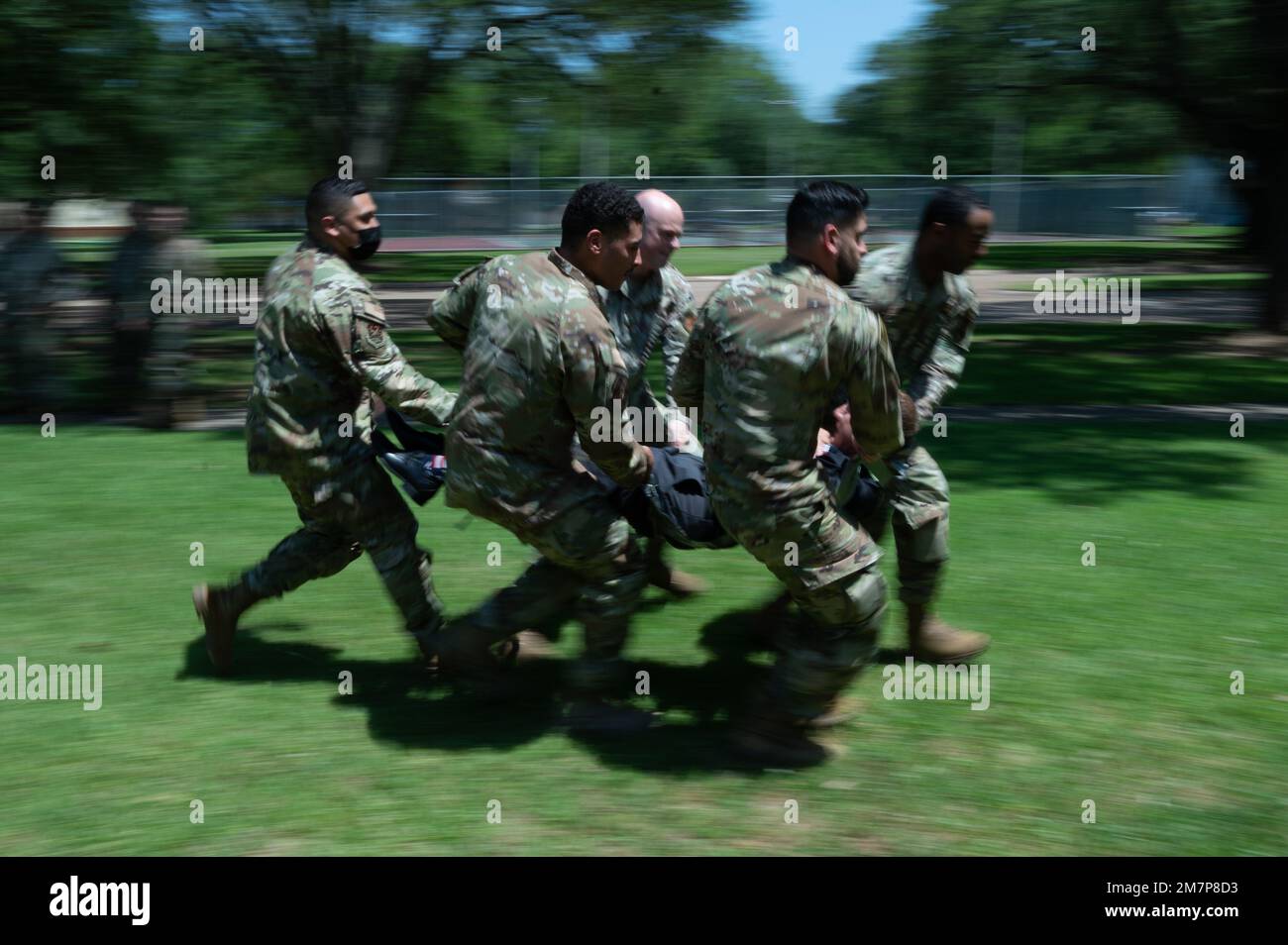 Ein Team von Airmen testet die Stärke der improvisierten Trage, die sie mit Klebeband während eines Teambuilding-Wettbewerbs von Striker Stripe am 11. Mai 2022 am Luftwaffenstützpunkt Barksdale, Louisiana, bauten. Jedes Team trug abwechselnd den Kursleiter in seinen Klebebandträgern, sodass jedes Team mit dem gleichen Gewicht konkurrierte. Stockfoto