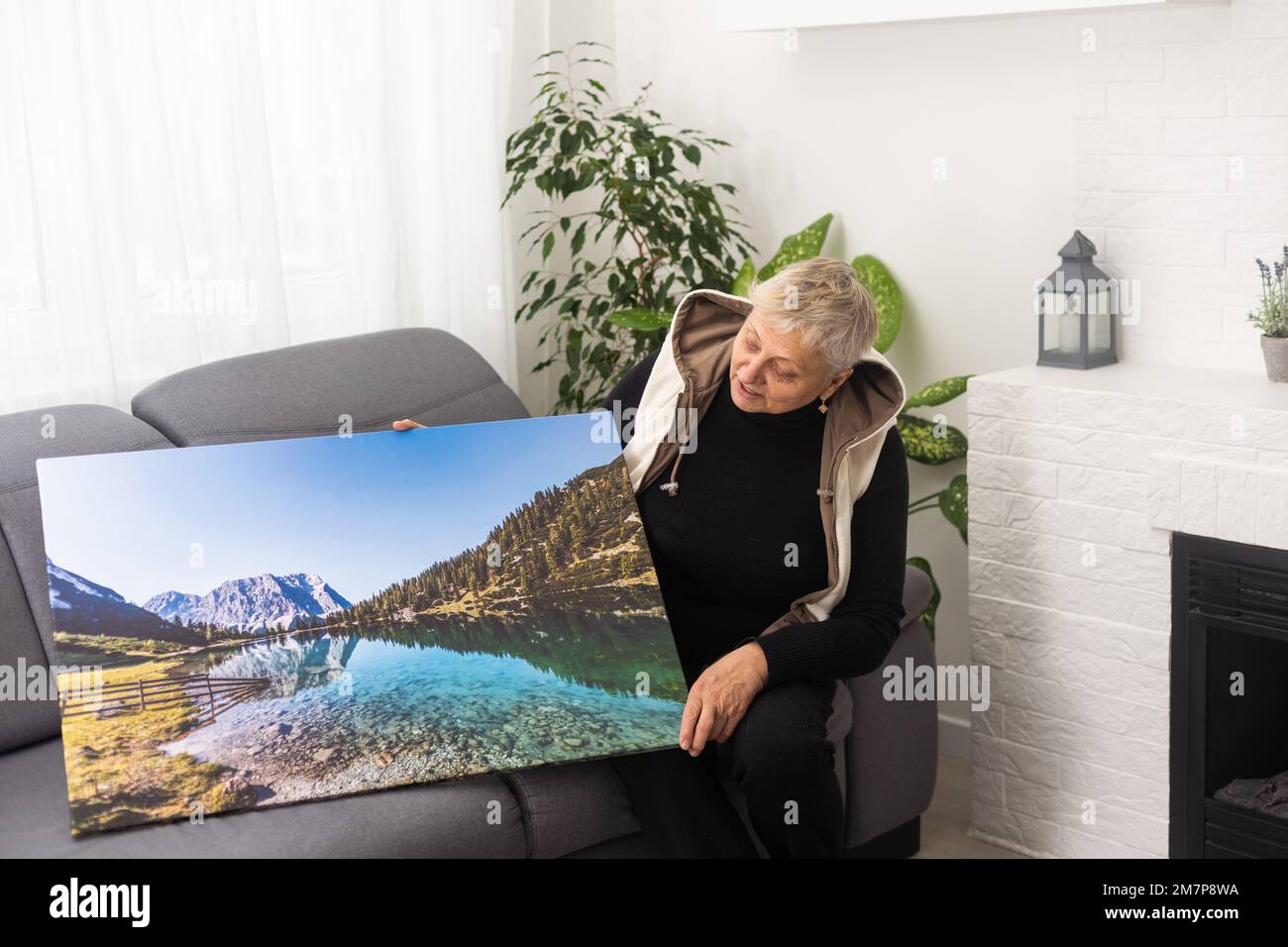 Moderne Inneneinrichtung Und Inneneinrichtung. Eine alte Frau mit einer Leinwand Stockfoto