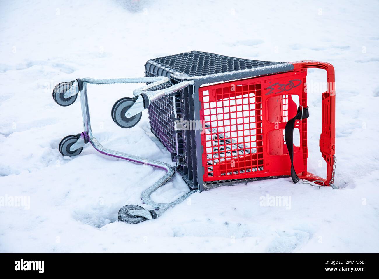 Umgestürzter Einkaufswagen oder Supermarkt-Trolley im Schnee Stockfoto