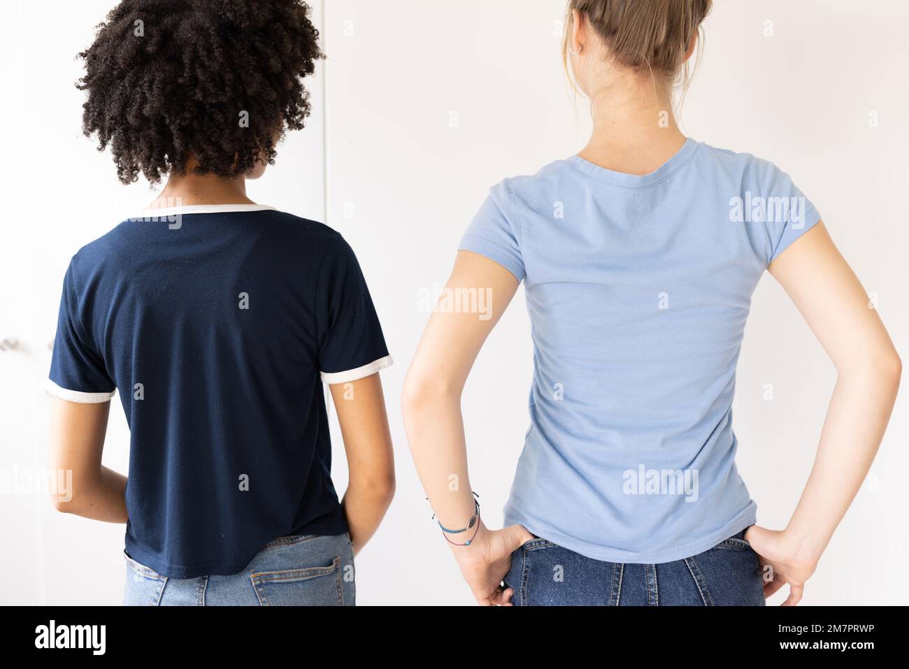 Bild der Rückansicht zweier verschiedener Frauen in T-Shirts mit Copyspace- und Jeanshose Stockfoto