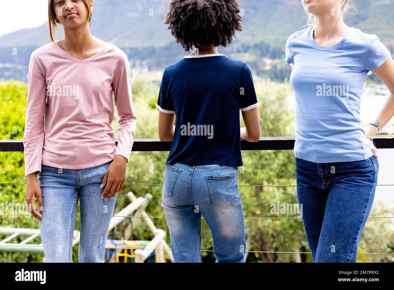 Bild von drei verschiedenen Frauen in T-Shirts mit Kopierraum und Denimhose mit Naturhintergrund Stockfoto