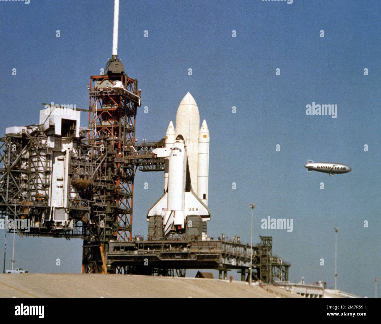 Der Goodyear Blimp fährt in der Nähe des Space Transportation System (STS) Shuttles. Das Shuttle, das mit den Armen ausgestattet ist, wird vor seinem Jungfernflug vorbereitet. Basis: Kennedy Space Center Bundesstaat: Florida (FL) Land: Vereinigte Staaten von Amerika (USA) Stockfoto