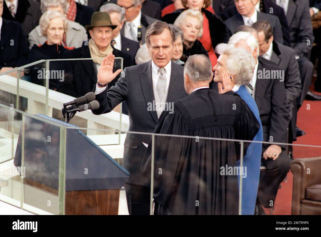 Im Capitol Building leistet George Bush den Amtseid als Vizepräsident der Vereinigten Staaten. Bushs Frau Barbara steht während der Feier des Amtseinweihungstags zu seiner Linken. Basis: Washington State: District of Columbia (DC) Land: Vereinigte Staaten von Amerika (USA) Stockfoto