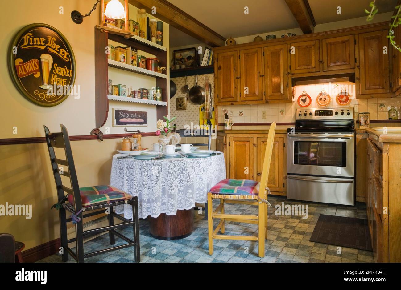 Antike Holzstühle und Frühstückstisch in der Küche im alten rekonstruierten  Blockhaus im Landhausstil aus dem Jahr 1850er, Quebec, Kanada. Dieses Bild  ist Eigenschaft rel Stockfotografie - Alamy
