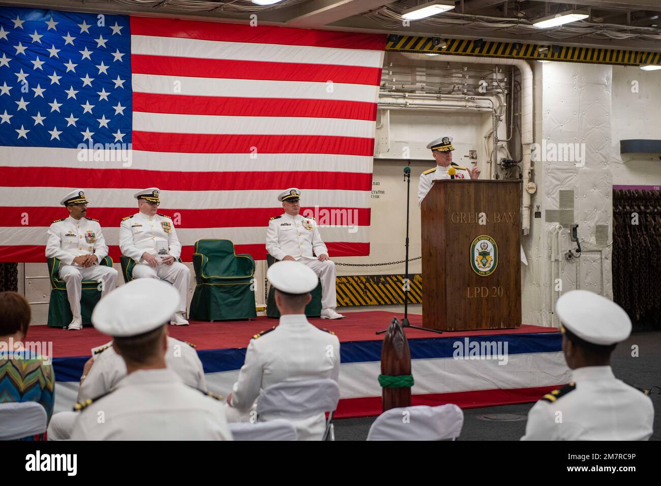 SASEBO, Japan (12. Mai 2022) Hinten ADM. Chris Engdahl, Befehlshaber, Expeditionary Strike Group 7, Vorsitzender des nach vorn eingesetzten Amphibiendockschiffs USS Green Bay (LPD 20), gibt während der Zeremonie im Fahrzeugladeraum des Schiffes Bemerkungen ab. Green Bay, Teil des Amphibiengeschwaders 11, ist im Zuständigkeitsbereich der US-amerikanischen 7.-Flotte tätig, um die Interoperabilität mit Verbündeten und Partnern zu verbessern und als einsatzbereite Eingreiftruppe zur Verteidigung von Frieden und Stabilität in der Region Indo-Pazifik zu dienen. Stockfoto