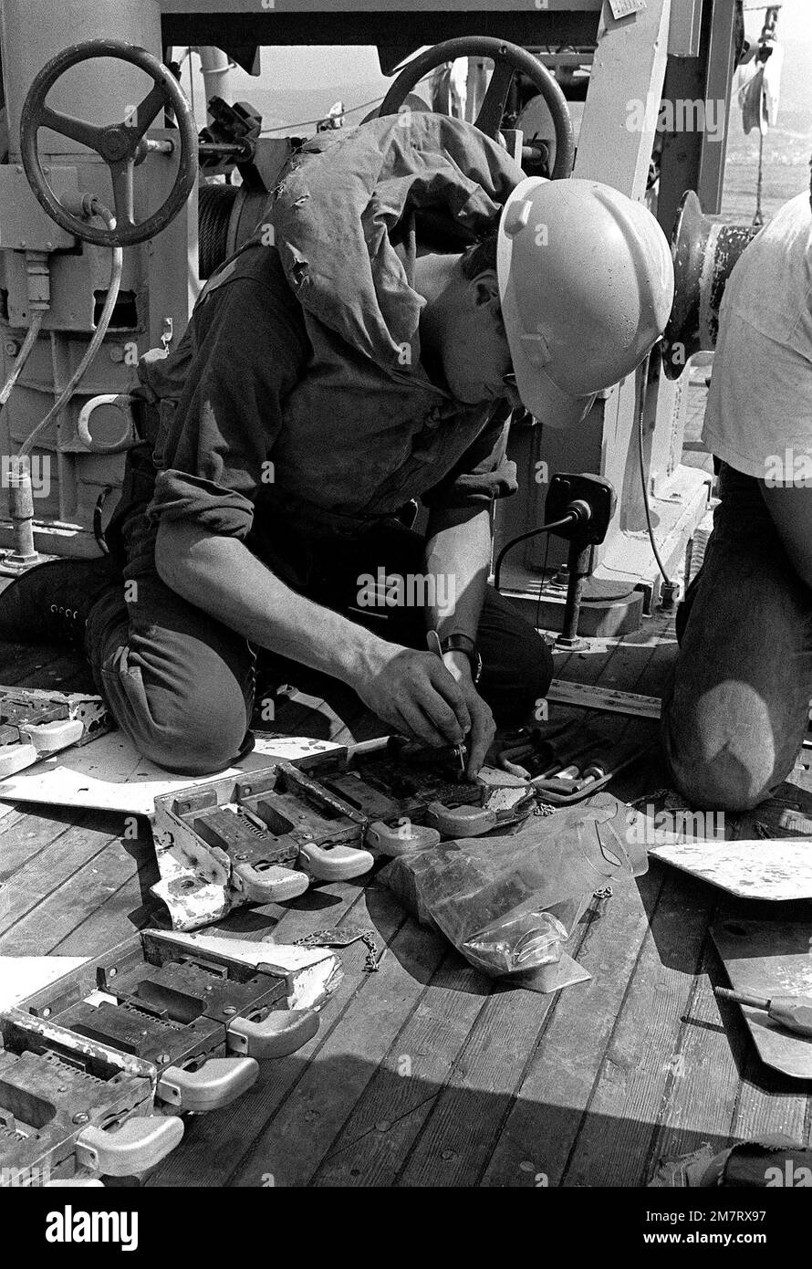 Ein Besatzungsmitglied auf dem Deck des Minenwasserbootes 51 (MSB-51) legt während der Übungen der Arbeitsgruppe für Abwehrmaßnahmen im Bergbau 1-81 (MCMTG 1-81) Ladungen auf einen Kabelschneider für Minenräumgeräte fest. Die Arbeitsgruppe, die aus Marinestützpunkten für sieben NATO-Länder besteht, wurde gebildet, um ihre Fähigkeiten zur Minenabwehr zu erhöhen. Land: Mittelmeer (MED) Stockfoto