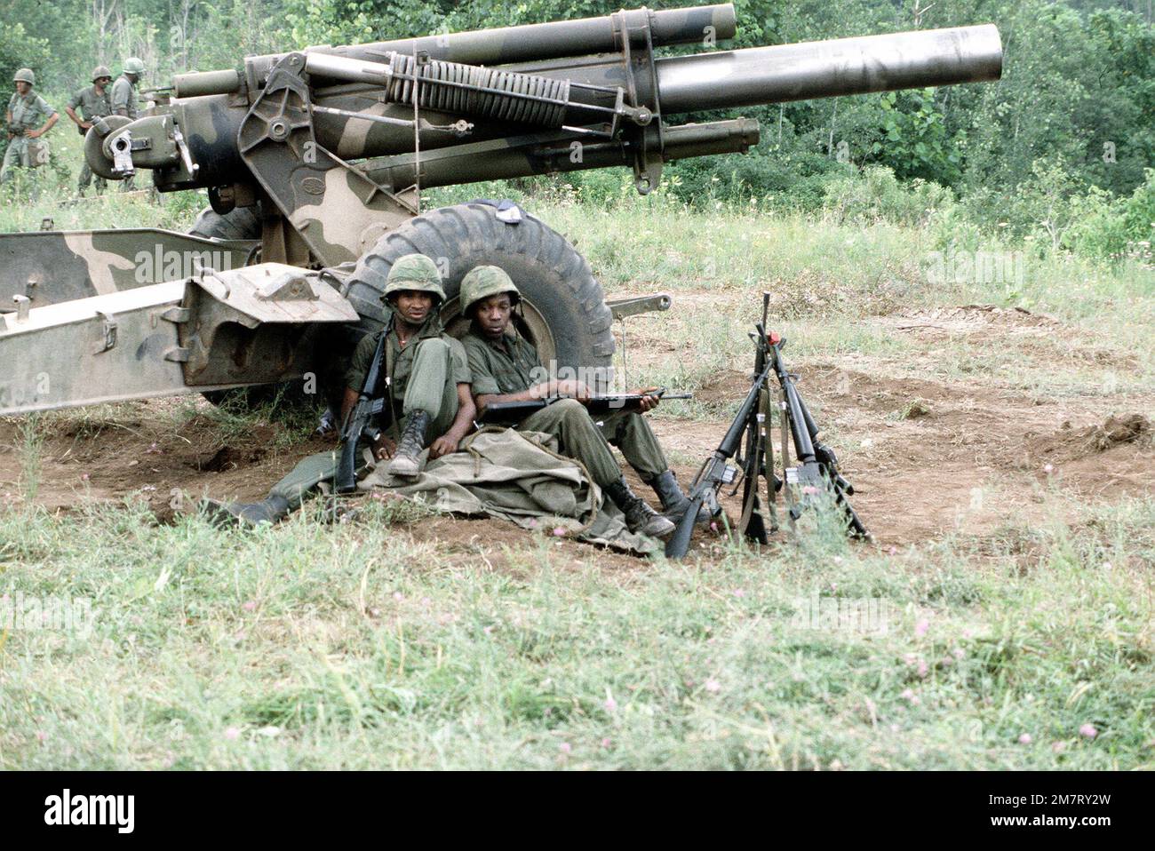 Zwei Armeesoldaten lehnen sich nach dem Feldtraining gegen einen M-114 155mm-Haubitzer an, der Teil der Übung Wentry Castle '81 war. Die Soldaten sind der Nationalgarde der Army zugeteilt. Betreff Operation/Serie: SENTRY CASTLE '81 Basis: Fort Drum Staat: New York (NY) Land: Vereinigte Staaten von Amerika (USA) Stockfoto