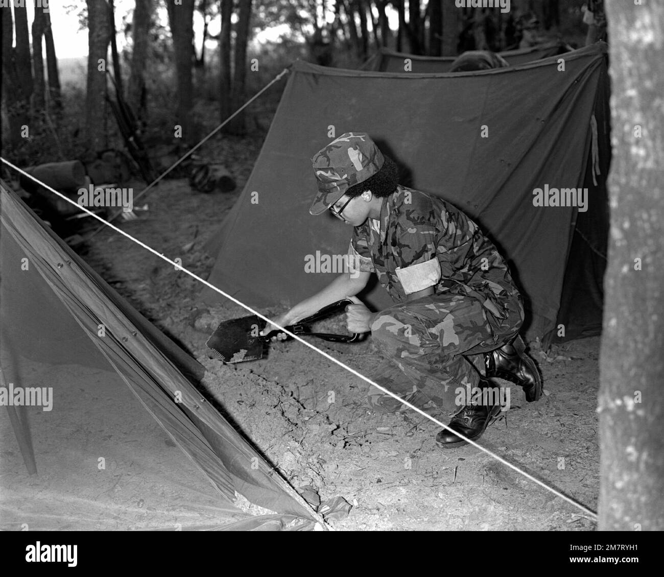 PVT. Page, eine Rekrutin der Marine, demonstriert die richtige Technik, um einen Abflussgraben um ein zwei-Personen-Zelt zu graben. Page, Mitglied der Serie 10a, trainiert auf Gibbs Island. Basis: USMC Recruit Depot, Parris Island Bundesstaat: South Carolina (SC) Land: Vereinigte Staaten von Amerika (USA) Stockfoto