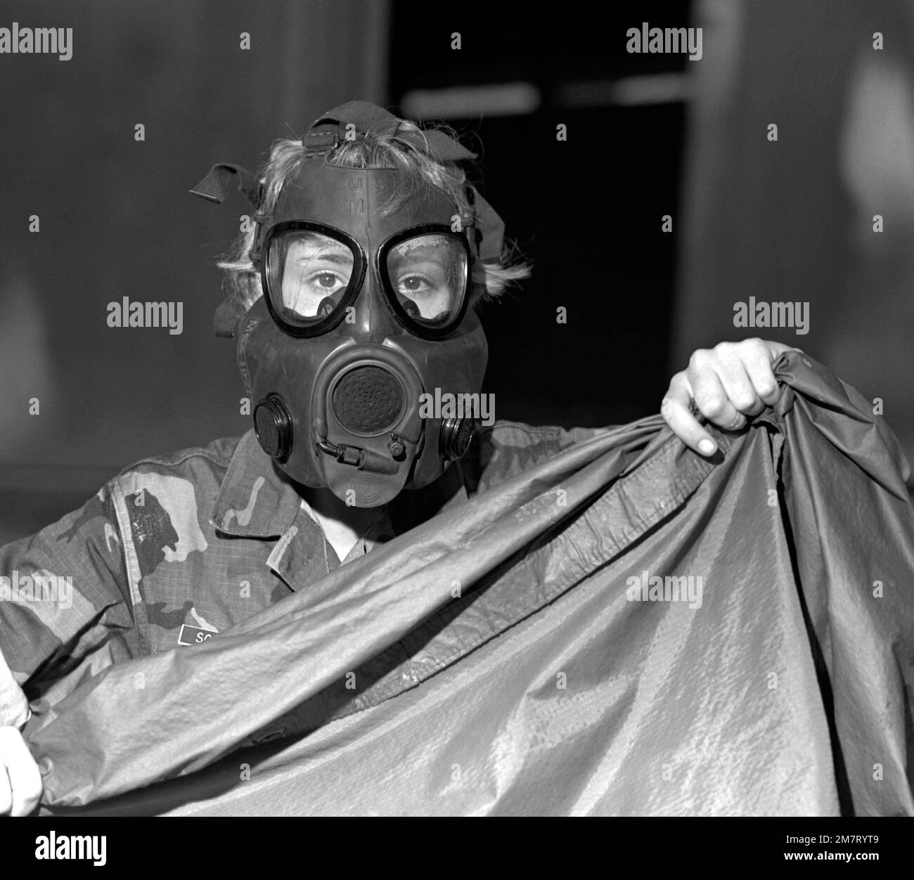 PVT J. M. Shettel von Serie 9a bereitet sich darauf vor, sich während eines Gasalarms mit ihrem Poncho zu bedecken. Die Schulung findet im Trainingsbereich Elliott's Beach statt. Basis: USMC Recruit Depot, Parris Island Bundesstaat: South Carolina (SC) Land: Vereinigte Staaten von Amerika (USA) Stockfoto