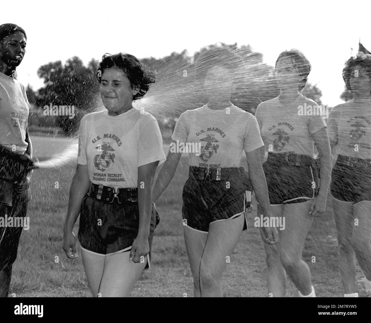Nach Abschluss des körperlichen Trainings schätzen die Rekrutiererinnen der Marine eine kühlende Dusche aus dem Schlauch. Basis: USMC Recruit Depot, Parris Island Bundesstaat: South Carolina (SC) Land: Vereinigte Staaten von Amerika (USA) Stockfoto