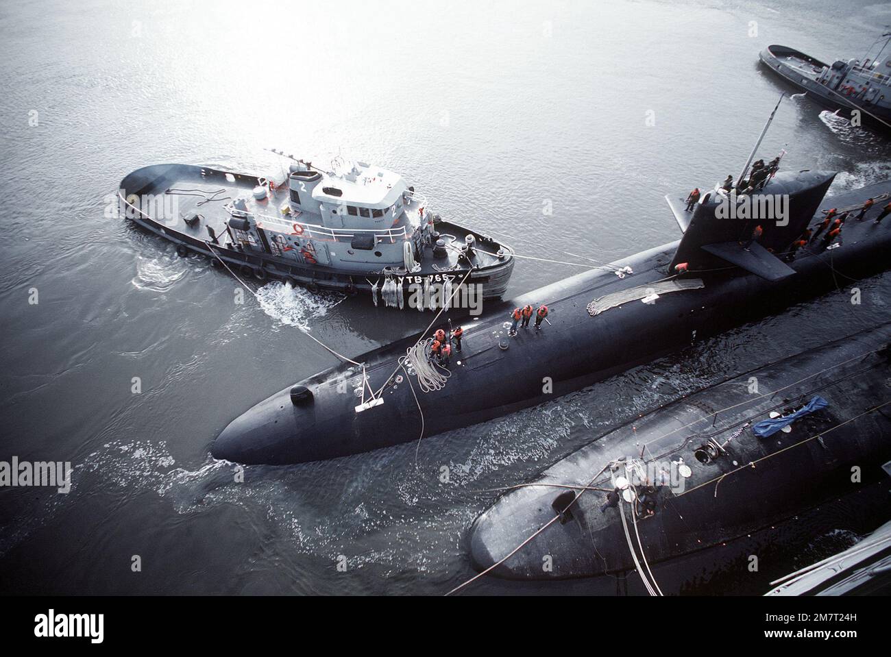 Der große Hafenschlepper USS OKMULGEE (YTB-765) manövriert ein nuklearbetriebenes U-Boot der Benjamin-Franklin-Klasse in die Andockposition. Basis: Kings Bay Bundesstaat: Georgia (GA) Land: Vereinigte Staaten von Amerika (USA) Stockfoto