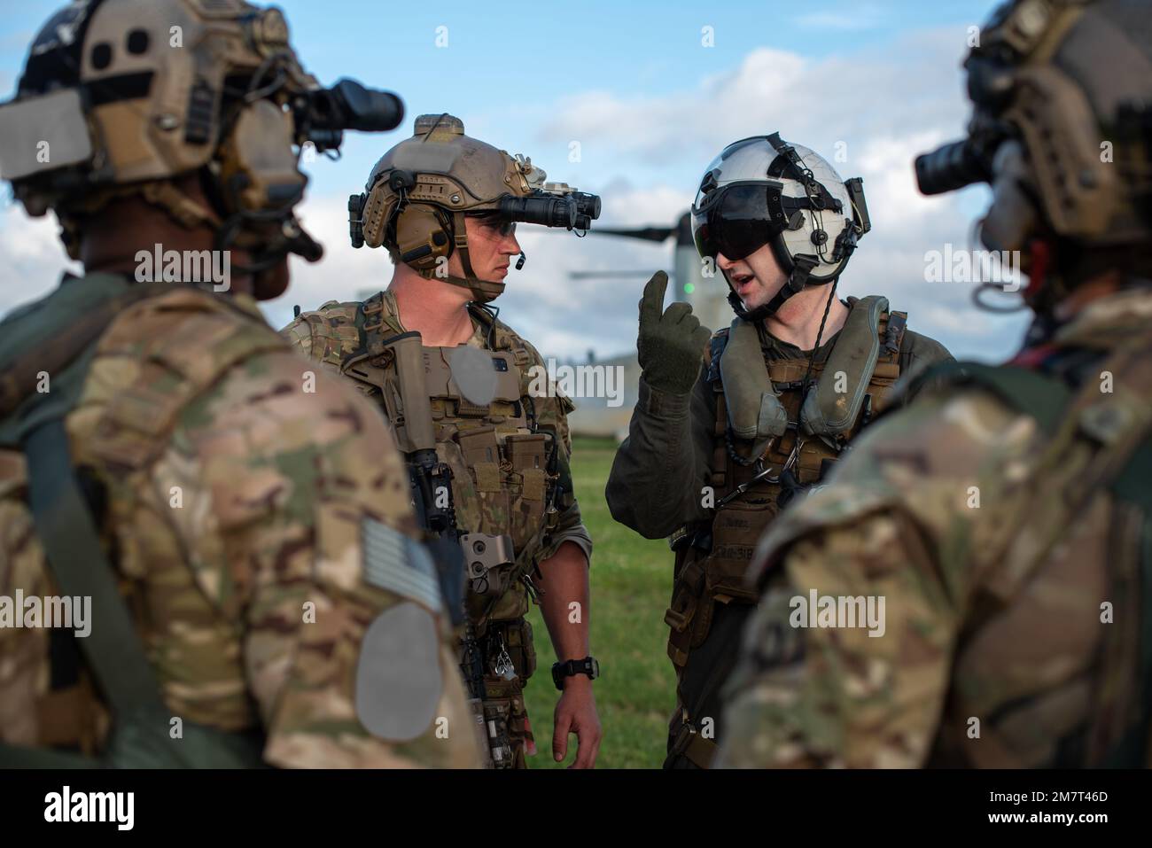 Ein 353. Special Operations Support Squadron entsandte ein Mitglied des Aircraft Ground Response Element Teams, das von einem Marine Medium Tiltrotor Squadron 265 MV-22 Osprey Piloten eingewiesen wird, bevor es das Flugzeug für eine abendliche Hubschrauberangriffstruppen-Trainingsmission am Bahnhof Torii, Okinawa, Japan, am 12. Mai 2022 besteigt. Die Ausbildung hat die ausländische interne Verteidigung der Special Forces durch eine Kombination von Angriffstruppen mit Mitteln wie einem Joint Terminal Attack Controller, Signals Intelligence und Mehrzweck-Kaninen geübt. Die Integration von Armee-, Marine-, Marine- und Luftwaffenkomponenten hat die Interoperabilität erhöht Stockfoto