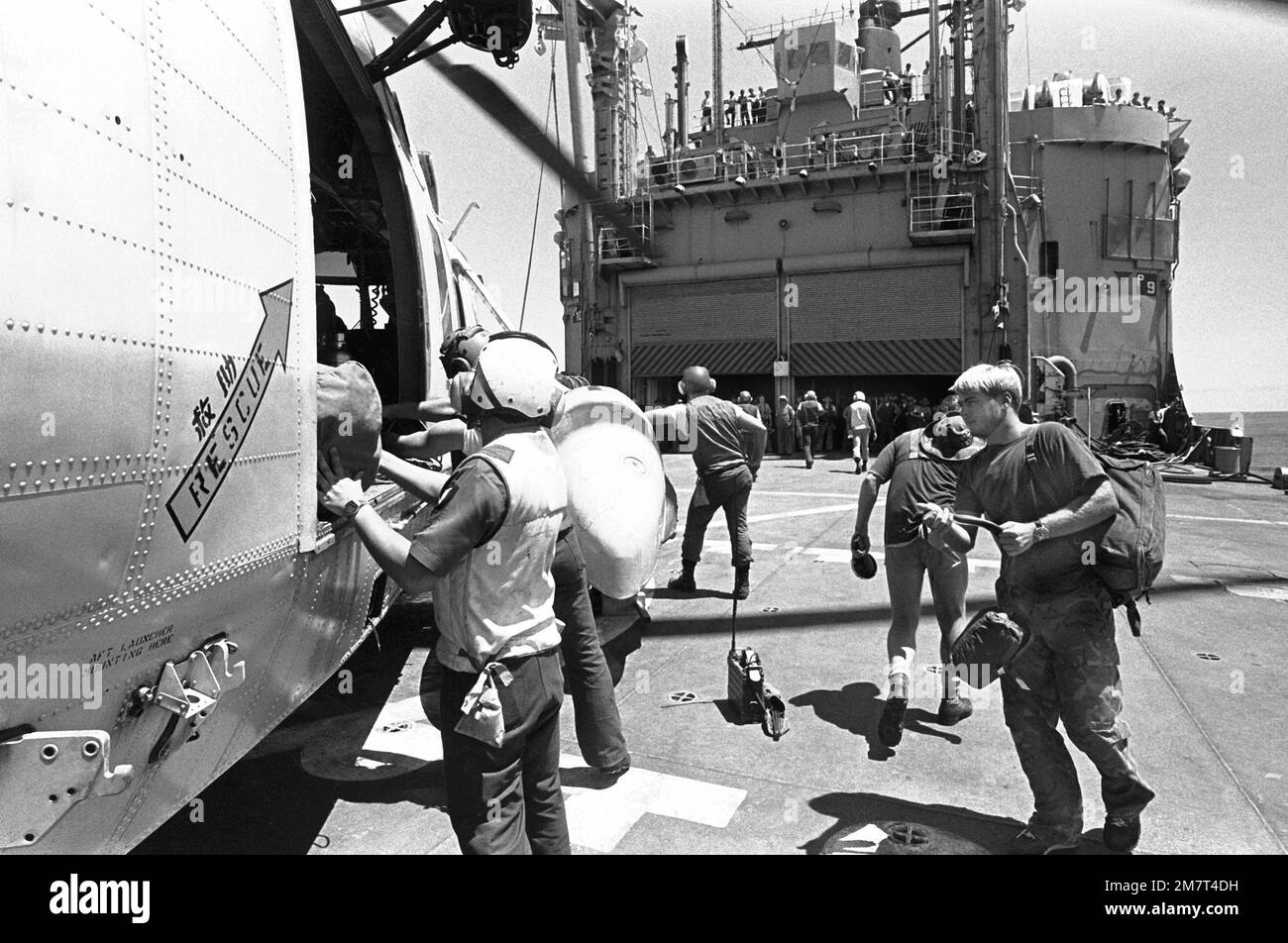 Besatzungsmitglieder laden Vorräte an Bord eines SH-3A Sea King Hubschraubers der Fleet Composite Squadron 5 (VC-5) auf das Helikopterfeld des Munitionsschiffs USS MOUNT HOOD (AE-29). Der Sea King wird die Vorräte zur Insel Calayan transportieren und sich an Such- und Rettungsaktionen (SAR) für die gestrandete und gestürzte philippinische Fregatte RPS DATU KALANTIAW (PS-76) beteiligen. Die Fregatte wurde von Taifun Clara überholt. Land: Philippinen (PHL) Stockfoto