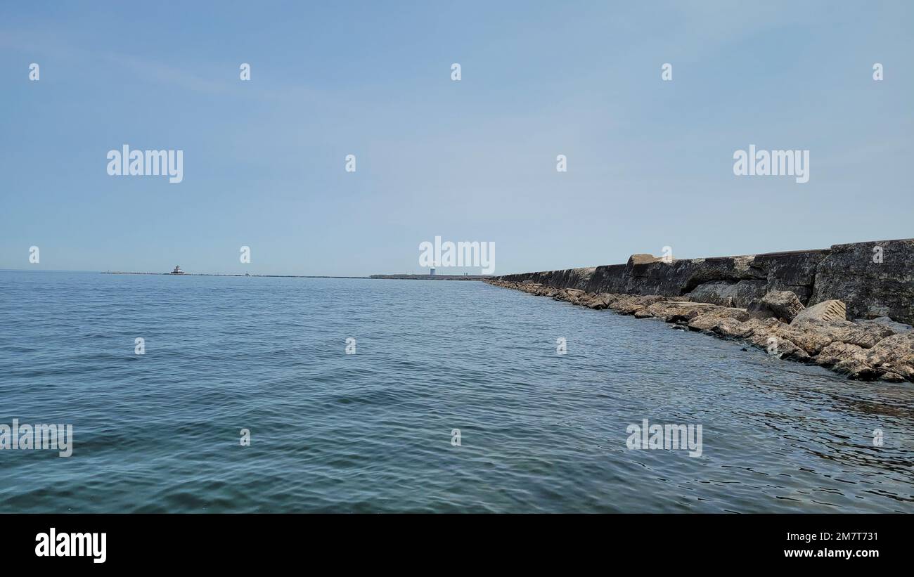 Ein Wellenbrecher erstreckt sich bis zum Hafen von Oswego und am Ufer des Lake Ontario in Oswego, New York, am 12. Mai 2022. Das Wellenbrecherwasser, das vom Buffalo District gepflegt wird, gewährleistet eine sichere Schifffahrt für gewerbliche und Freizeitschiffe, die auf den Großen Seen und dem Oswego River fahren. Stockfoto