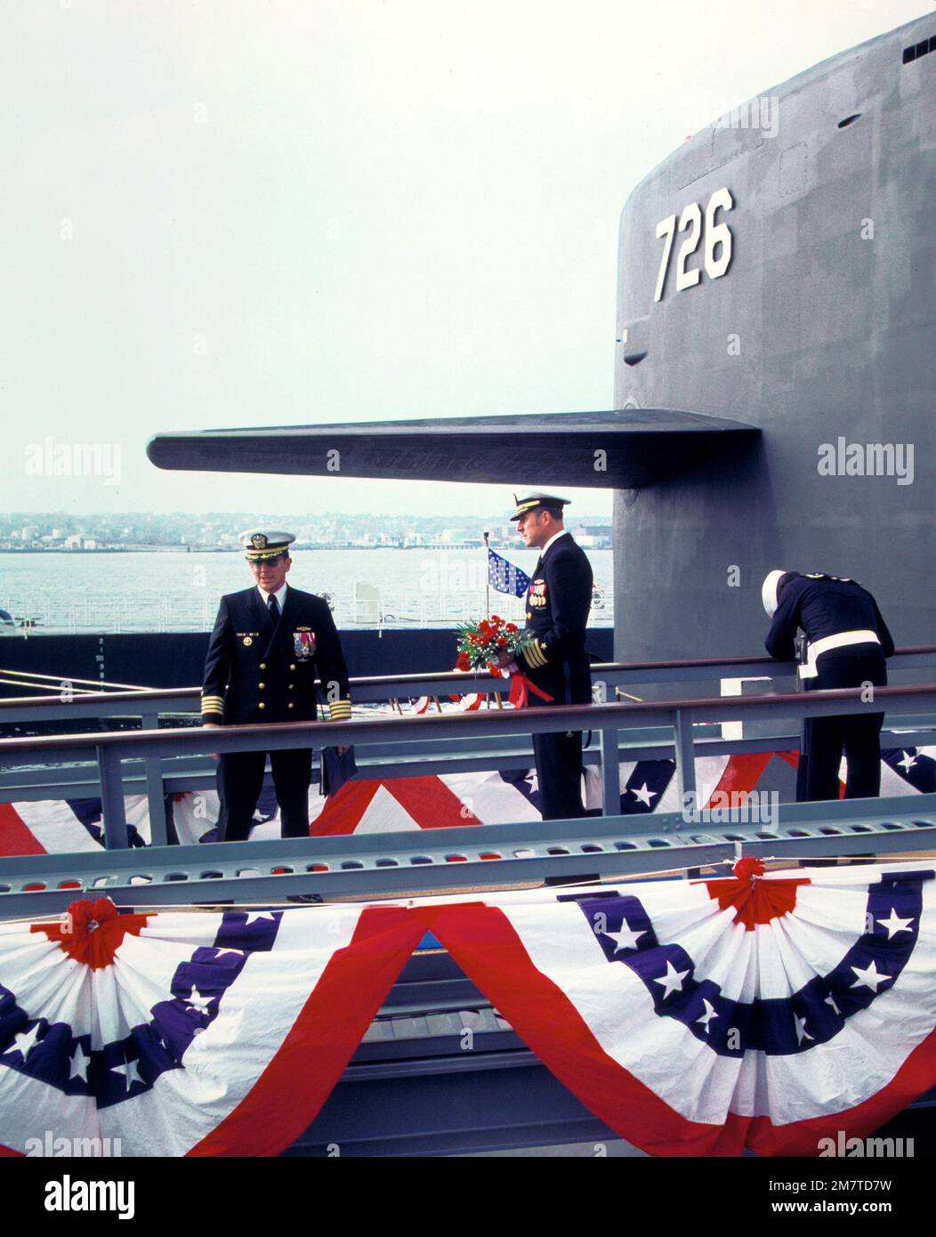 CAPTAIN Alton K. Thompson, links, befehlshabender Offizier (blaue Crew), und CAPT Arlington F. Campbell, befehlshabender Offizier (goldene Crew), stehen neben dem Segel des nuklearbetriebenen U-Boots USS OHIO (SSBN-726), bevor sie einem Ehrengast während der Zeremonie Blumen überreichen. Der Gewerkschafts-Jack winkt im Hintergrund. Basis: U-Boot-Stützpunkt, Groton Bundesstaat: Connecticut (CT) Land: Vereinigte Staaten von Amerika (USA) Stockfoto