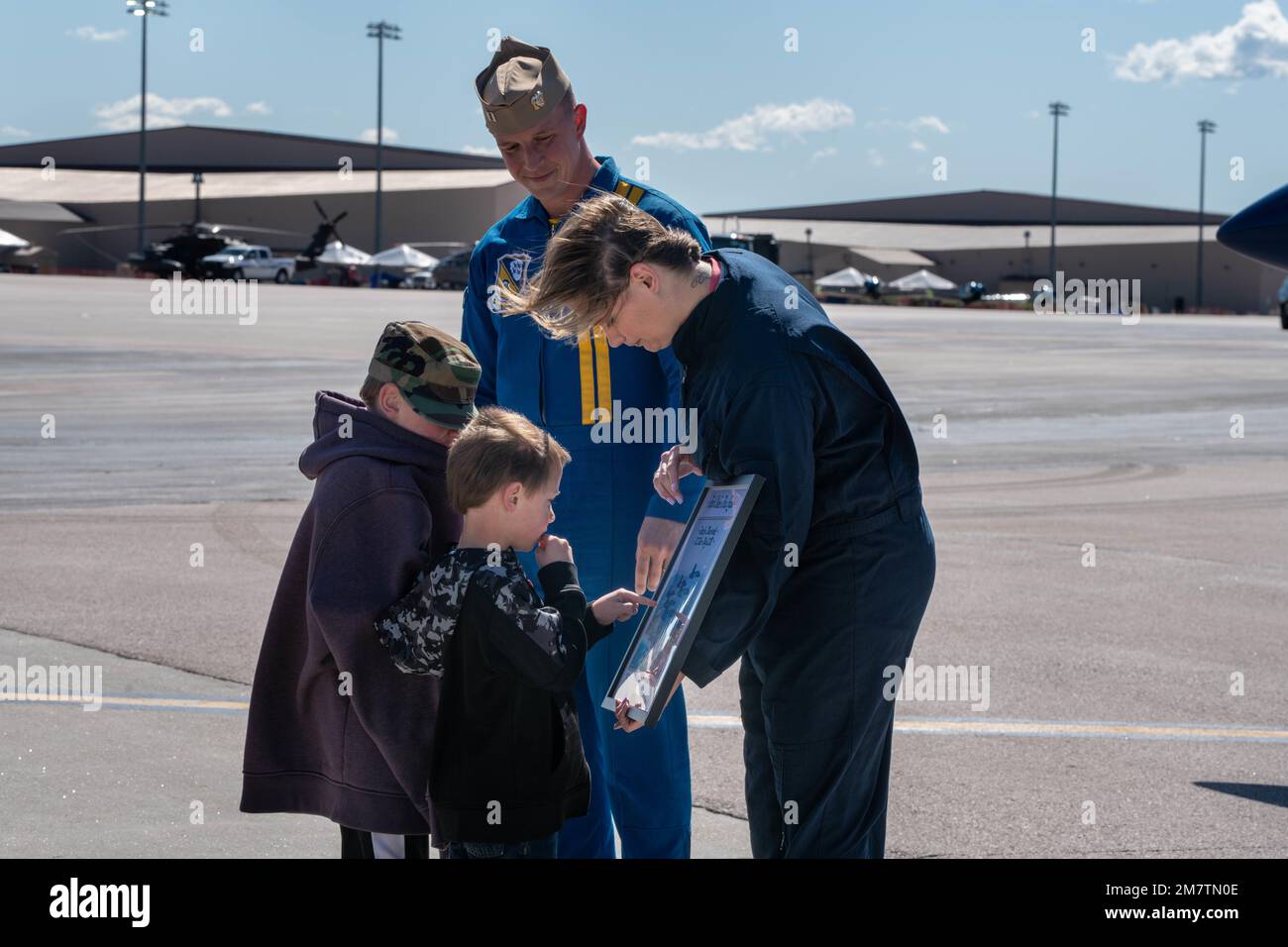 Jennifer Macziewski, Rapid City, Lehrerin des Jahres in South Dakota, zeigt ihren Kindern eine Lithographie, die ihr von den USA präsentiert wird Navy LT. Griffin Stangel, Pilotin und Erzähler der Blue Angels, und nach ihrem Prämienflug auf einem US-amerikanischen Navy Blue Angels, F/A-18 Super Hornet auf dem Luftwaffenstützpunkt Ellsworth, 13. Mai 2022. Macziewski wurde im Rahmen der Ellsworth Air and Space Show, Ellsworth AFB, South Dakota, als wichtigster Einflussnehmer für den Flug mit Stangel ausgewählt. Stockfoto