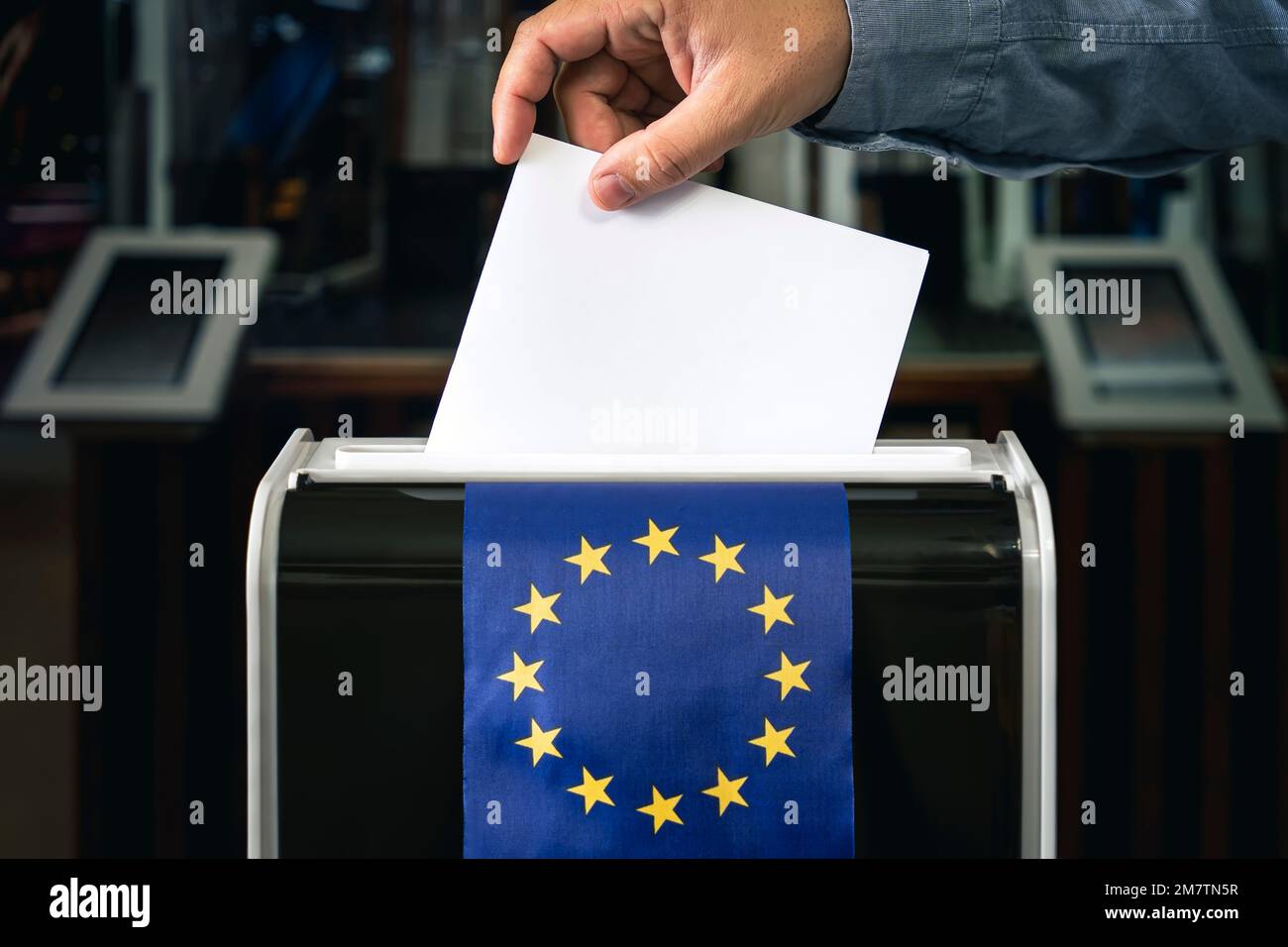 Mann, der bei den Wahlen in europa Wahlzettel in eine Kiste legt. Kopierraum, Europaflagge Stockfoto