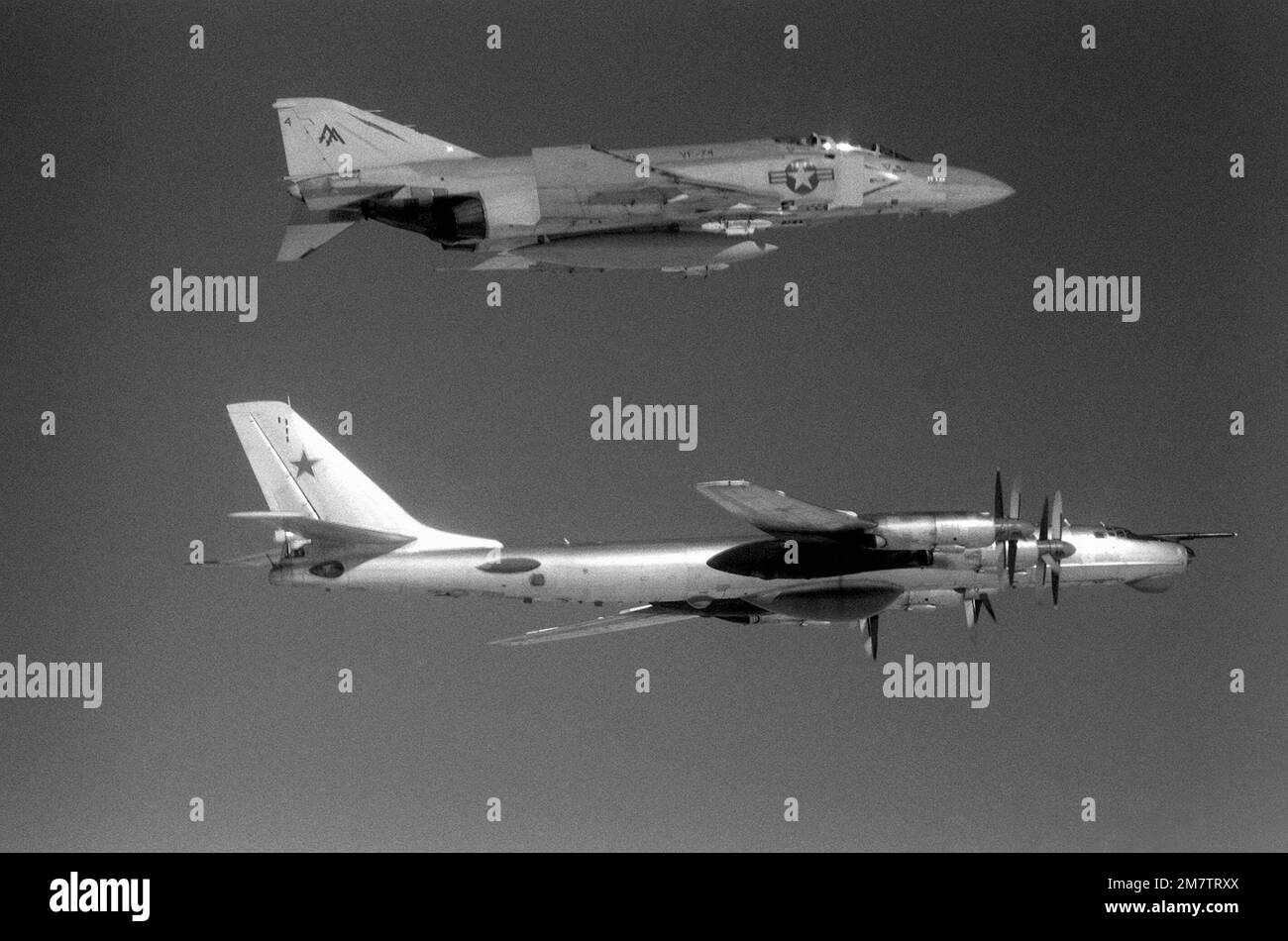 Eine Luftaufnahme eines US-Flugzeugs Navy F-4 Phantom II Flugzeug, Top, von Fighter Squadron 74 (VF-74) und ein sowjetisches TU-95 Tupolev Bear Flugzeug etwa 42 Meilen vor der Küste von Virginia. Die F-4 begleitet die in Kuba ansässige TU-95, die gerade in die US-Luftwaffenzone eingedrungen ist, um Seeversuche des neuen nuklearbetriebenen Flugzeugträgers CARL VINSON (CVN-70) aus der Vogelperspektive zu betrachten. Land: Atlantik (AOC) Stockfoto
