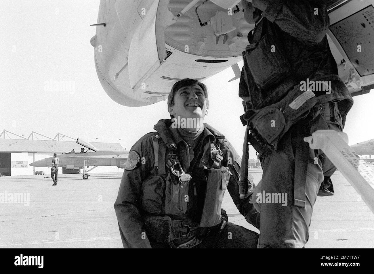 Der Marinesekretär John F. Lehman Jr., der vor der Kamera steht, spricht mit einem Mitglied des Fighter Attack Squadron 125 (VFA-125), das Wartungsarbeiten an einem F/A-18 Hornet-Flugzeug durchführt. Lehman, ein qualifizierter Pilot, wird die Hornet während eines Besuchs der Staffel fliegen. Basis: Marineflugstation, Lemoore Bundesstaat: Kalifornien (CA) Land: Vereinigte Staaten von Amerika (USA) Stockfoto