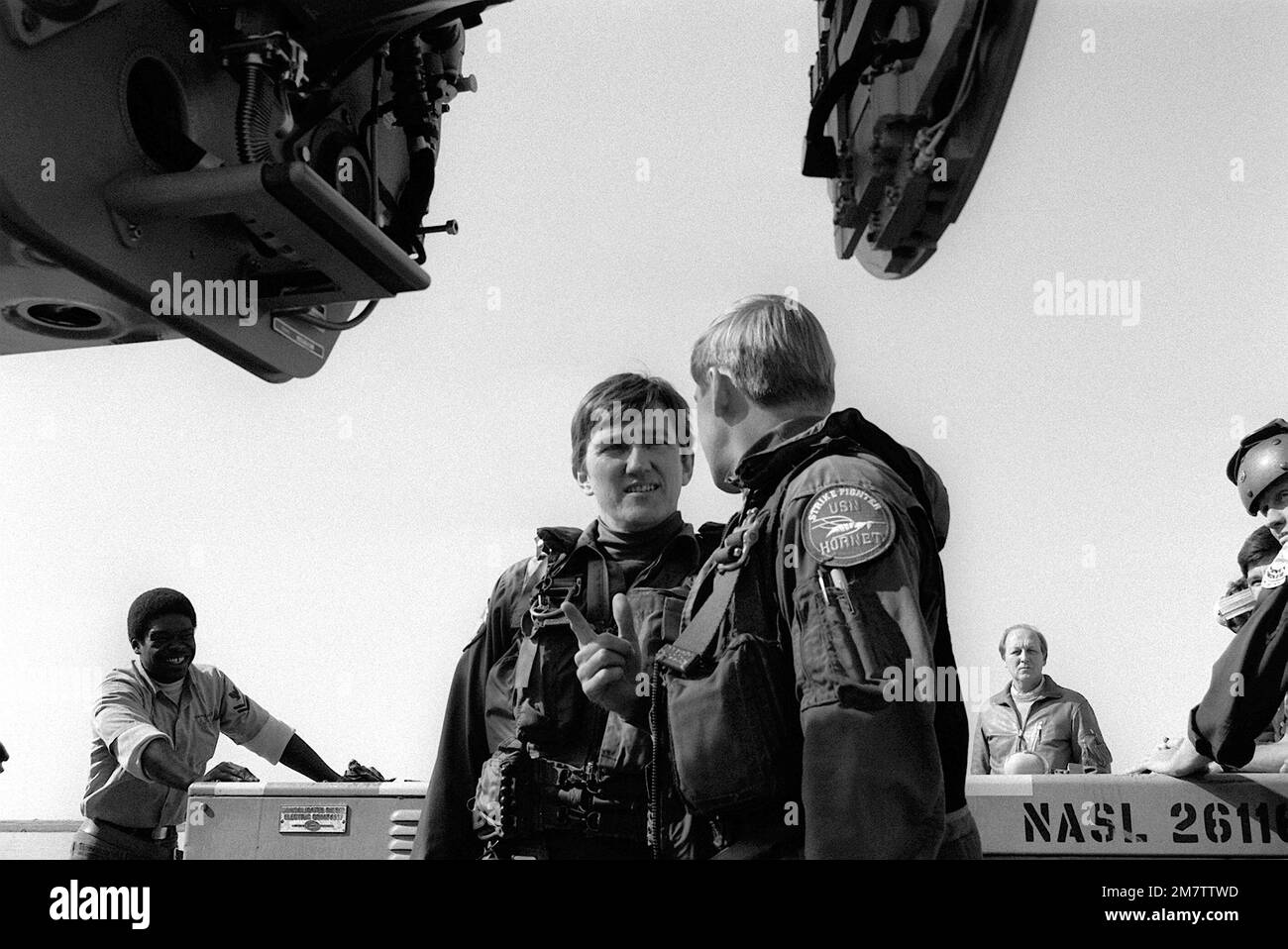 Der Marinesekretär John F. Lehman Jr. (vor der Kamera) spricht mit einem Mitglied des Kampfgeschwaders 125 (VFA-125). Lehman, ein qualifizierter Pilot, wird während seines Besuchs im Geschwader das F/A-18 Hornet Flugzeug fliegen. Basis: Marineflugstation, Lemoore Bundesstaat: Kalifornien (CA) Land: Vereinigte Staaten von Amerika (USA) Stockfoto