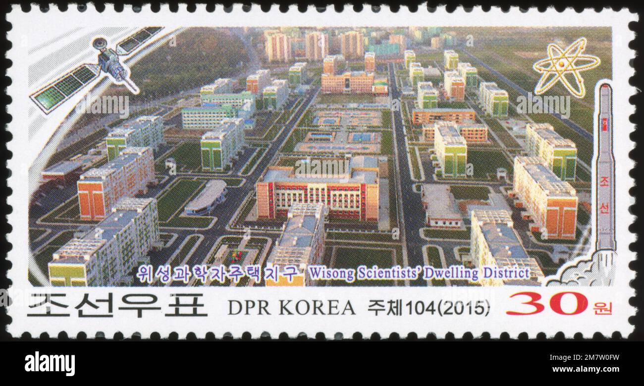 2015 nordkoreanische Briefmarke mit dem Wohnbezirk der Wisong-Wissenschaftler mit Satelliten-, Raketen- und Atomsymbolen. Stockfoto