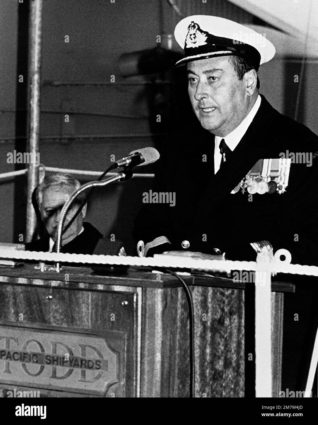 Commodore E.E. Johnson von der Royal Australian Navy, spricht während der Startzeremonie für die Fregatte DARWIN (F-04), die bei der Todd Pacific Shipyards Corporation stattfindet. Basis: Seattle Staat: Washington (WA) Land: Vereinigte Staaten von Amerika (USA) Stockfoto