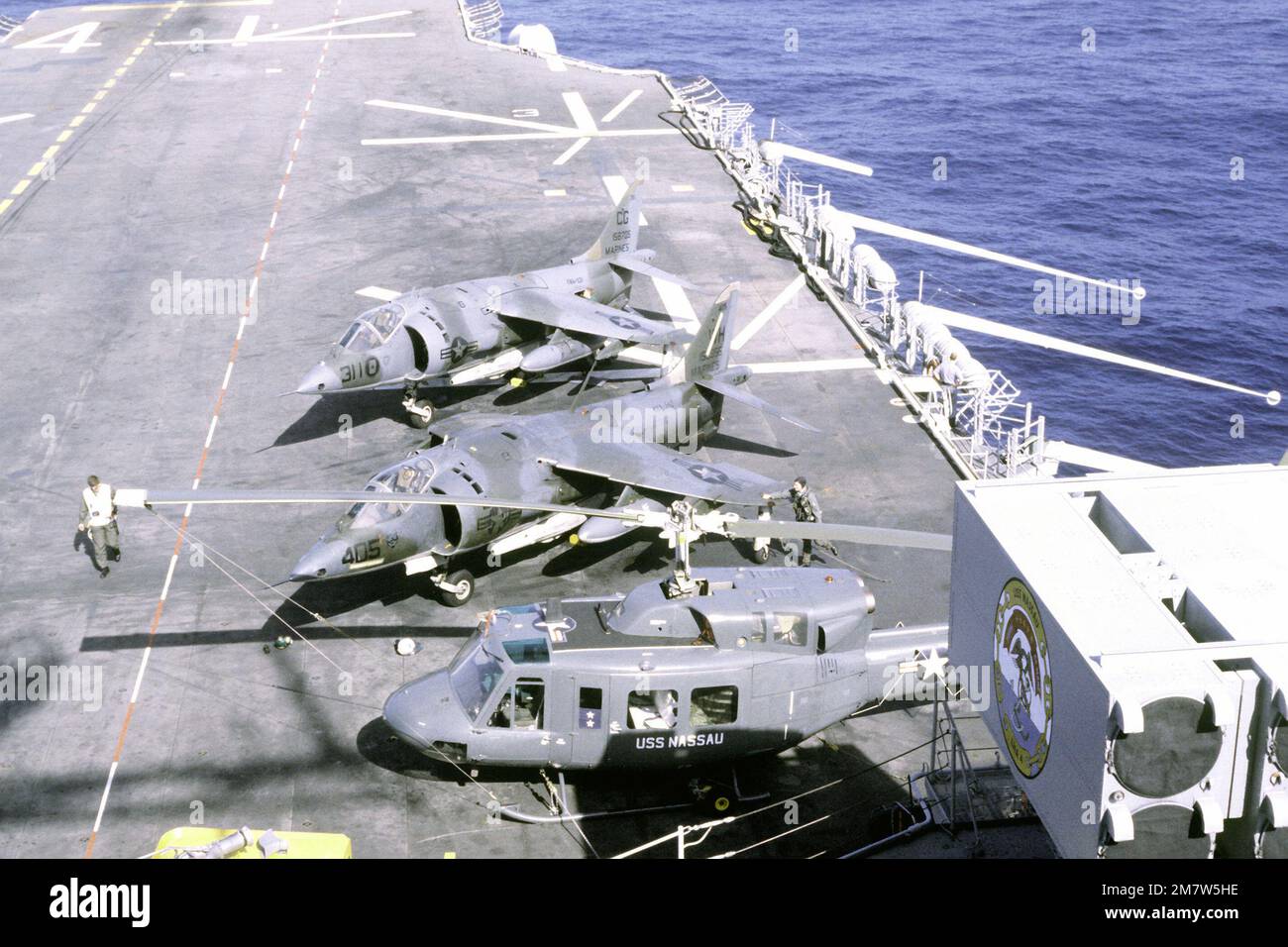 Auf dem Cockpit des Amphibienschiffs USS NASSAU (LHA-4) stehen zwei Hubschrauber AV-8A Harrier und ein UH-1 Iroquois. Land: Atlantik (AOC) Stockfoto