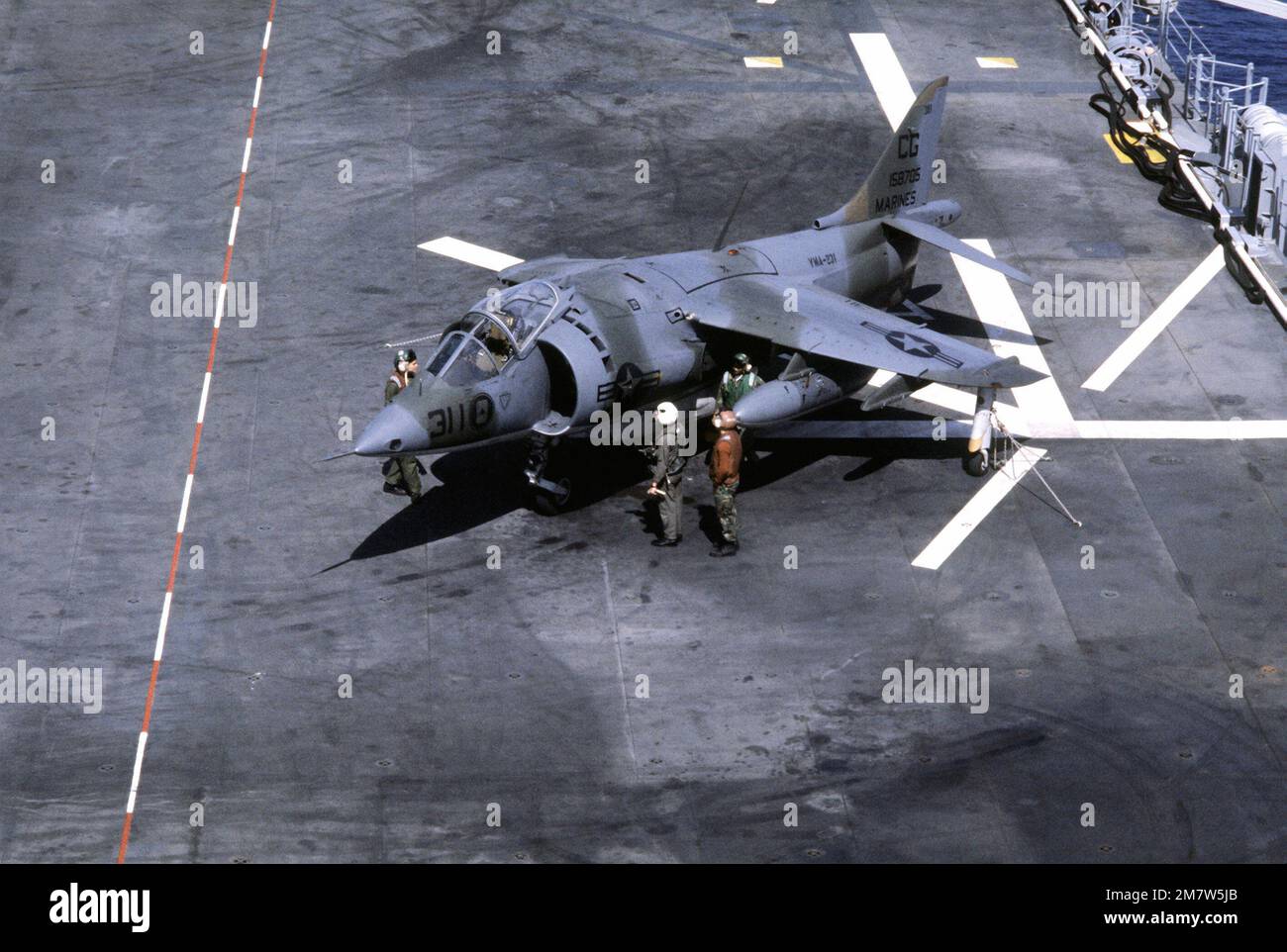 Flugdeck-Besatzungen bereiten ein AV-8A Harrier-Flugzeug für den Flug an Bord des Amphibienschiffs USS NASSAU (LHA-4) vor. Land: Atlantik (AOC) Stockfoto