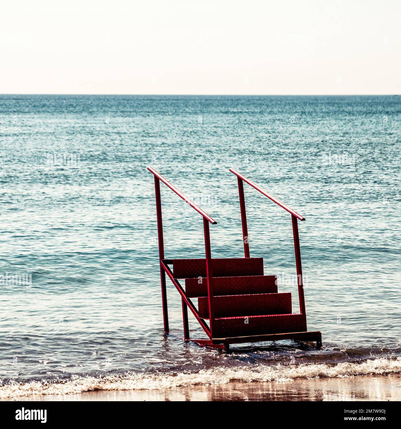 Leere Treppen zum nirgendwo am Strand mit Meer im Hintergrund. Stockfoto