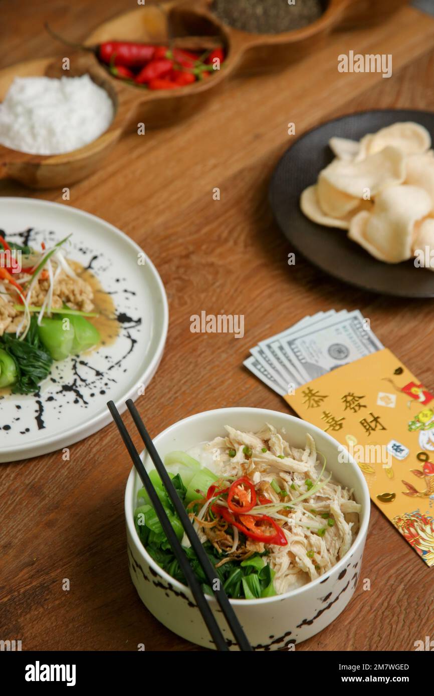 Essen am Mond-Silvester auf dem Tisch mit goldenem Umschlag gefüllt mit Geld als Zeichen des Glücks im neuen Jahr. Stockfoto