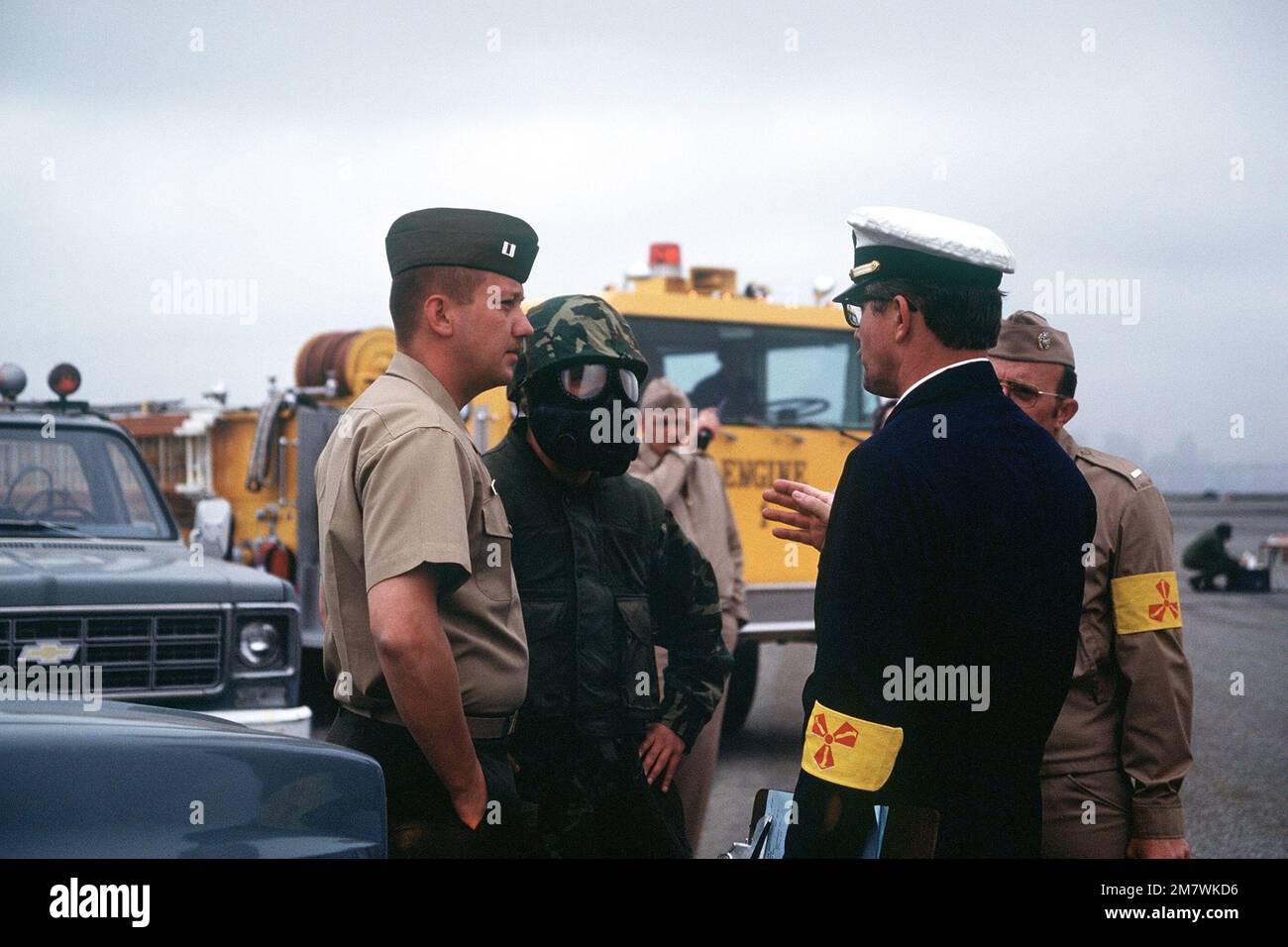 Von links: CAPT Bruce Besemer, CHIEF Warrant Officer Richard Davidson und LT. J. G. Jerry Richardson diskutiert mit einem Marine in Schutzkleidung die Strategie für Katastrophenübungen. Basis: Marineflugstation, Alameda Bundesstaat: Kalifornien (CA) Land: Vereinigte Staaten von Amerika (USA) Stockfoto
