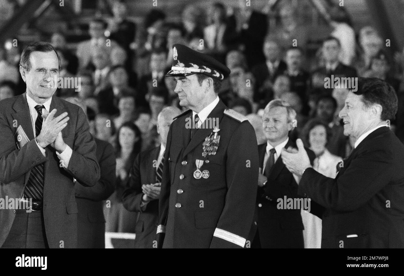 Vizepräsident George Bush (links), Verteidigungsminister Caspar Weinberger (rechts) und die Ehrengäste stehen während der Ruhestandszeremonie für GENERAL David C. Jones, Chairman, Joint Chiefs of STAFF (Center). Basis: Luftwaffenstützpunkt Andrews Bundesstaat: Maryland (MD) Land: Vereinigte Staaten von Amerika (USA) Stockfoto