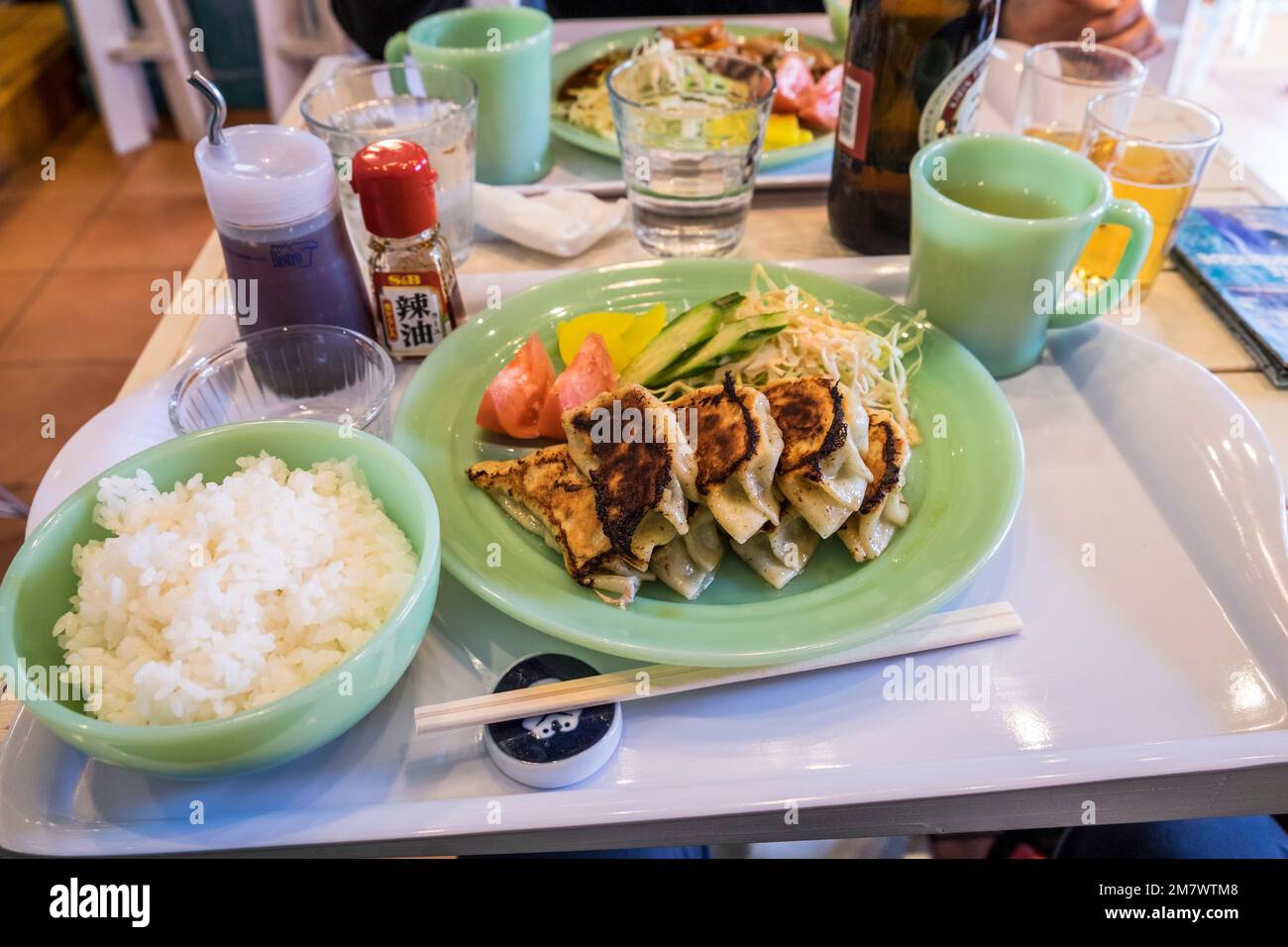 Japan, Kamakura, Honshu: Ein Tablett mit Gyosa, Schweineknödeln (Ravioli), Salat und Reis in einem Café Stockfoto