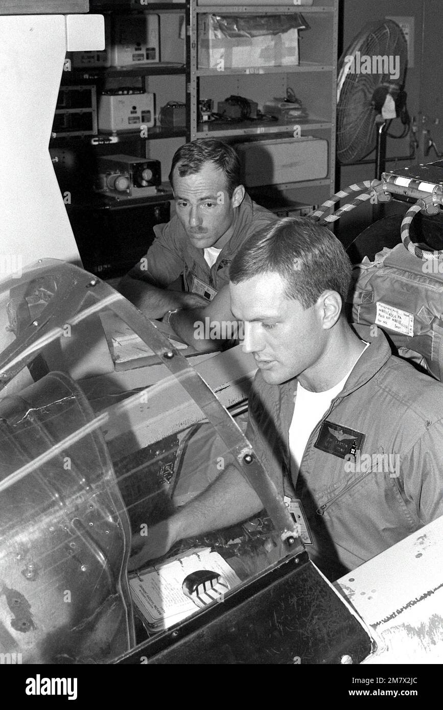 1lt Jim Larson sitzt im Cockpit eines F-4 Phantom II Flugsimulators. Er wird von CPT Paul Andres unterstützt. Basis: Marine Corps Air Station, Yuma Bundesstaat: Arizona (AZ) Land: Vereinigte Staaten von Amerika (USA) Stockfoto