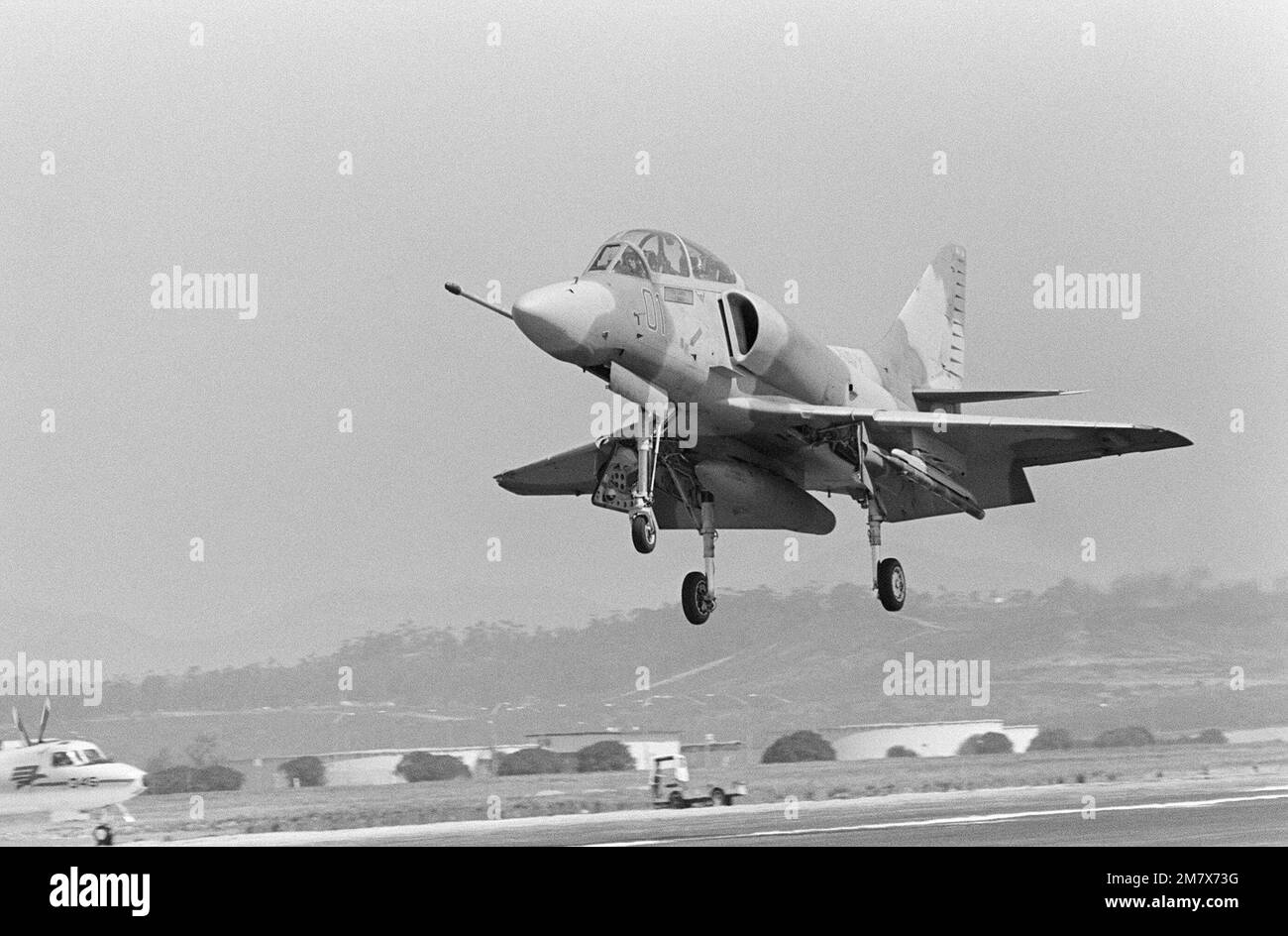 Ein Flugzeug der TA-4 Skyhawk, das als Tarnung der Luftwaffe des Sowjetblocks lackiert wurde, landet nach einer Trainingsmission auf der Flugstation. Die TA-4 ist der Navy Fighter Weapons School zugeteilt, die als „Top Gun“ bezeichnet wird, die Flugmanövering (ACM) für Navy- und Marine Corps-Piloten anbietet. Basis: Marineflugstation, Miramar Bundesstaat: Kalifornien (CA) Land: Vereinigte Staaten von Amerika (USA) Stockfoto