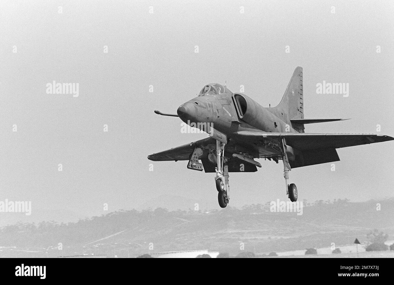 Ein 4E Skyhawk-Gegenflugzeug, das die Tarnung der Luftwaffe des Sowjetblocks simuliert, landet nach einer Trainingsmission auf der Flugstation. Die A-4E ist der Navy Fighter Weapons School zugeteilt, die als „Top Gun“ bezeichnet wird, die Flugmanövering (ACM) für Navy- und Marine Corps-Piloten anbietet. Basis: Marineflugstation, Miramar Bundesstaat: Kalifornien (CA) Land: Vereinigte Staaten von Amerika (USA) Stockfoto