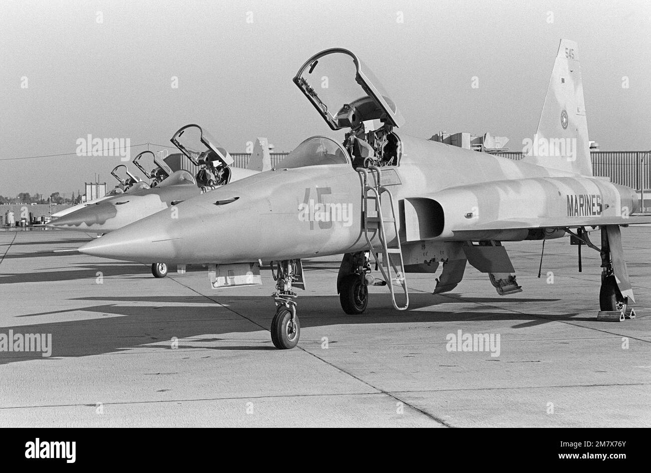 Eine linke Vorderansicht von vier gegnerischen F-5E Tiger II Flugzeugen, die in einer Reihe auf der Fluglinie geparkt sind. Die Flugzeuge werden von der Navy Fighter Weapons School, bekannt als „Top Gun“, verwendet, um Flugmanöver (ACM) für Navy- und Marine Corps-Piloten zu trainieren. Die Flugzeuge sind so lackiert, dass sie Tarnmuster der Luftwaffe des Sowjetblocks simulieren. Basis: Marineflugstation, Miramar Bundesstaat: Kalifornien (CA) Land: Vereinigte Staaten von Amerika (USA) Stockfoto