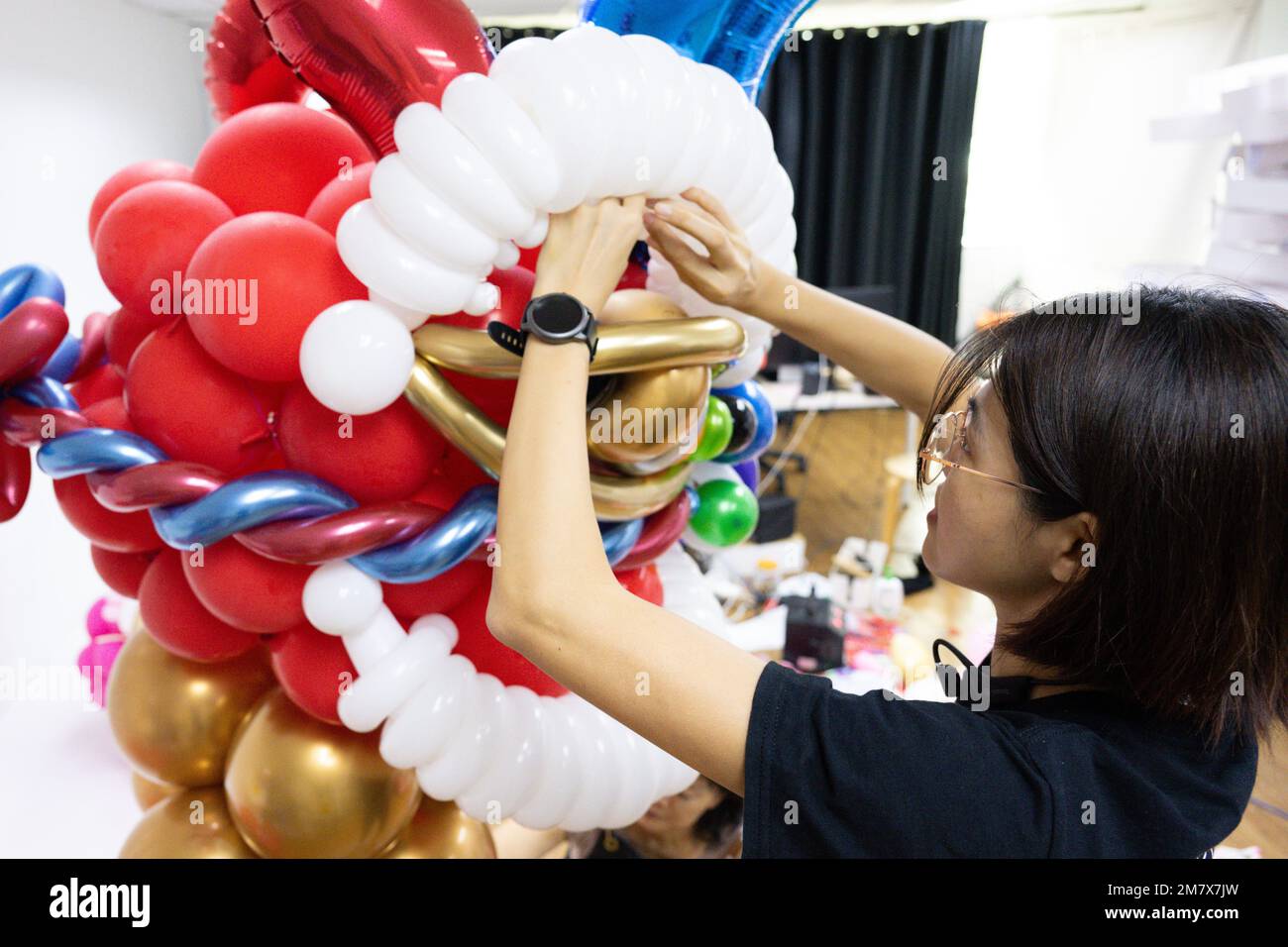 (230111) -- KUALA LUMPUR, 11. Januar 2023 (Xinhua) -- Syndy Tan Sing Yit stellt in ihrer Werkstatt in der Nähe von Kuala Lumpur, Malaysia, am 11. Januar 2023 eine Ballonskulptur mit Löwentanz ein. Syndy Tan Sing Yit ist ein malaysischer Stylist, der seit über einem Jahrzehnt an der Ballonmodellierung arbeitet. Sie hat Ballonskulpturen für Löwentanz geschaffen, indem sie sich auf Grafiken und Bilder von Löwentanz bezieht. Laut Tan benötigt die Herstellung einer Ballonskulptur mit Löwentanz mehr als 500 Ballons, bei denen es wichtig ist, die Farbe der Augen und das Verhältnis von Lippen und Kinn anzupassen, um den Charme des li hervorzuheben Stockfoto