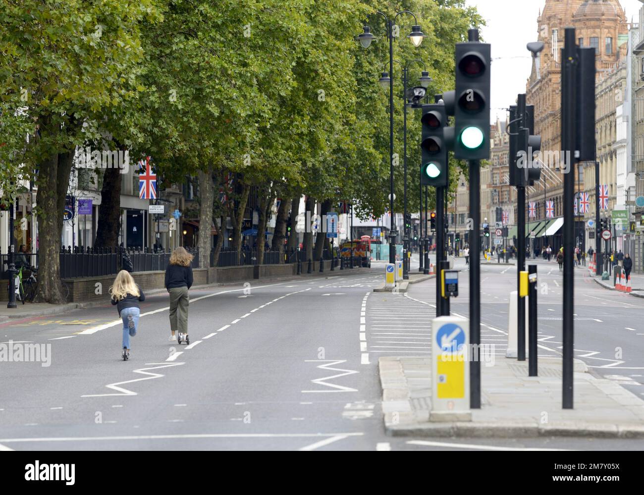 London, England, Großbritannien. Zwei junge Mädchen auf Rollern in einer fast verlassenen Knightbridge am Tag der Beerdigung von Königin Elizabeth II., 19. September 2022 Stockfoto