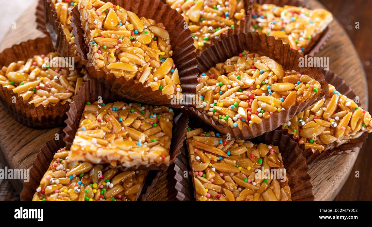 Desserts mit Mandeln, Erdnüssen und Samen in Karamell. Traditionelle sardische Süßigkeiten. Süße Quadrate. Almond Gateau, Sarda Food, für Smartphones und soziale Netzwerke. Banner Stockfoto