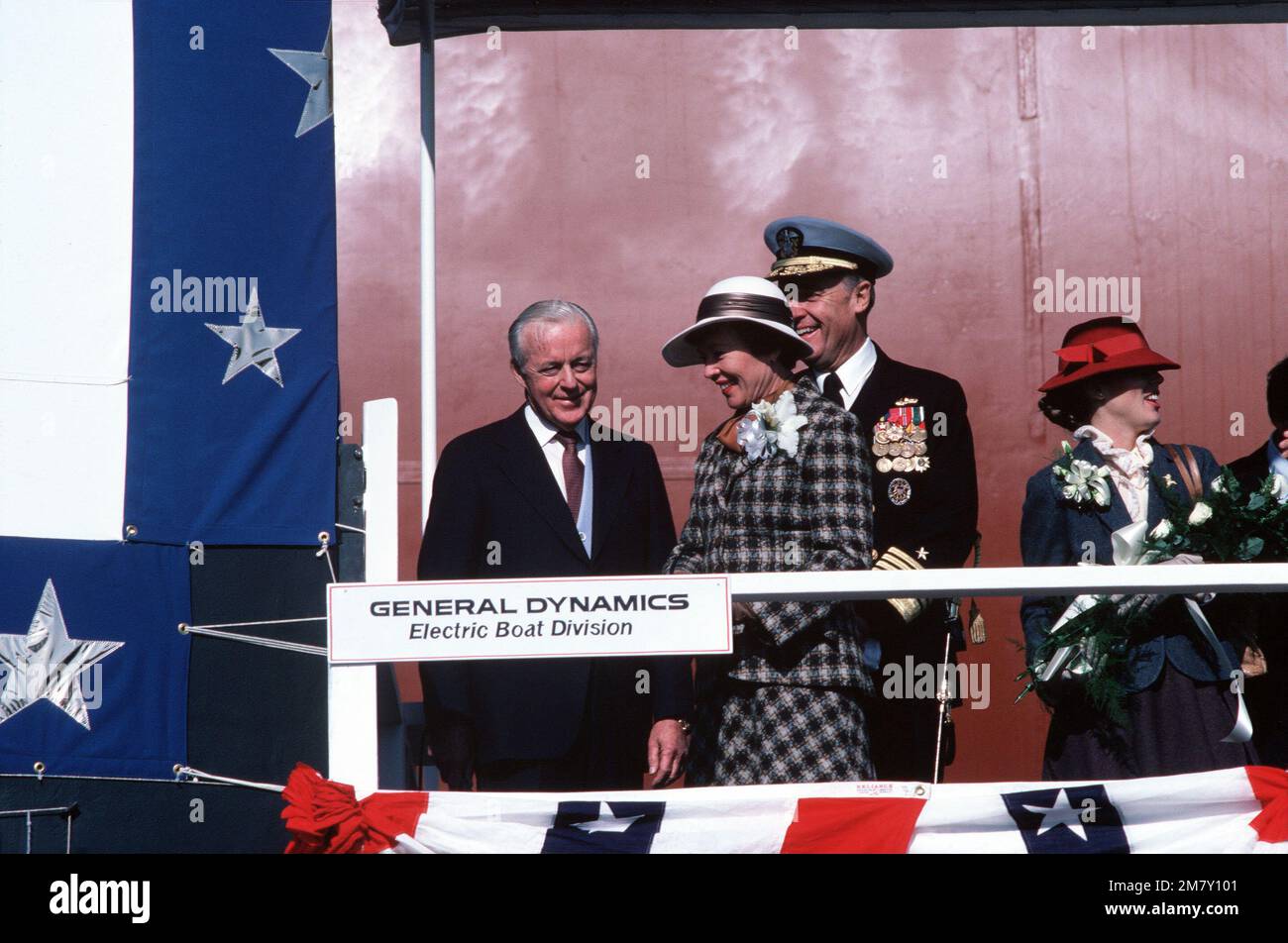 Auf der Rednerplattform (von links nach rechts) nehmen David S. Lewis, Vorstandsvorsitzender von General Dynamics, Sponsor Sheila McKinney Watkins, Susan Watkins, Ehrenfrau, an der Startzeremonie für das nuklearbetriebene strategische Raketenunterseeboot USS GEORGIA (SSBN 729) Teil. Admiral James D. Watkins, Chef der Marineeinsätze, ist im Hintergrund zu sehen. Basis: U-Boot-Stützpunkt, Groton Bundesstaat: Connecticut (CT) Land: Vereinigte Staaten von Amerika (USA) Stockfoto