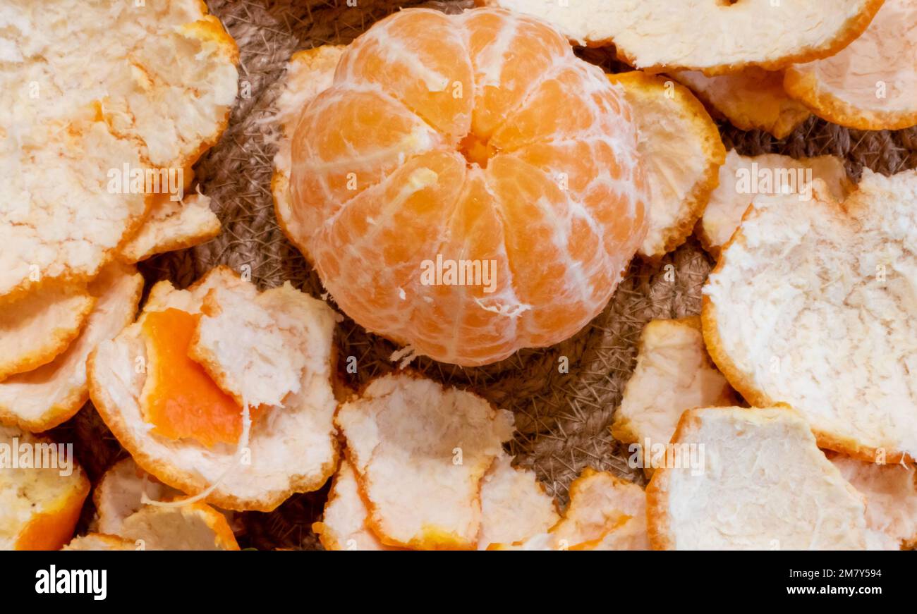 Geschälte, reife Mandarine in der Mitte der Schale Nahaufnahme auf dem Esstisch Stockfoto