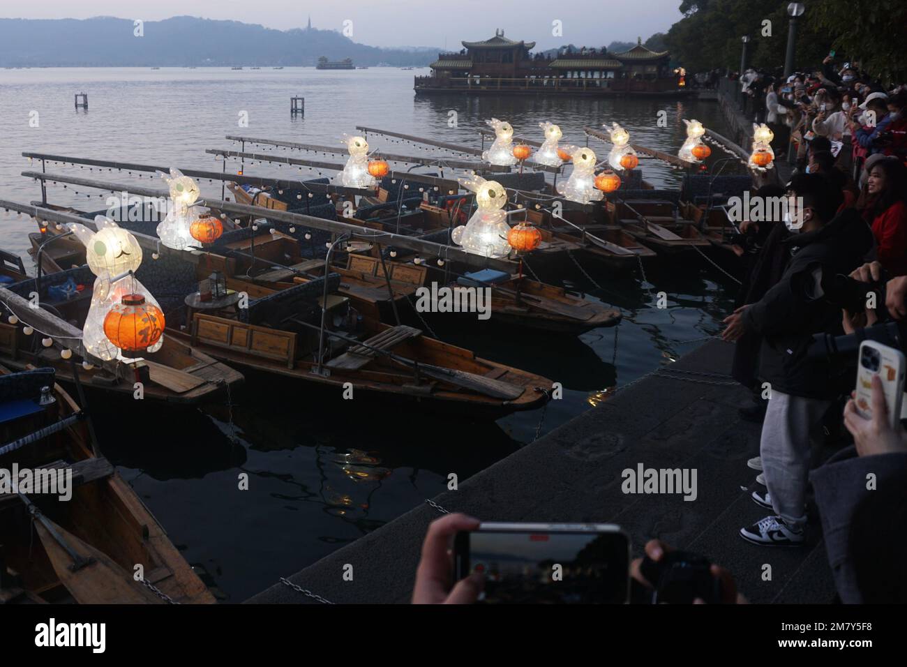 HANGZHOU, CHINA - 11. JANUAR 2023 - Eine große Anzahl von Bürgern und Touristen beobachtete und fotografierte handgezogene Boote, die mit Jade Rabbit Lant ausgestattet waren Stockfoto