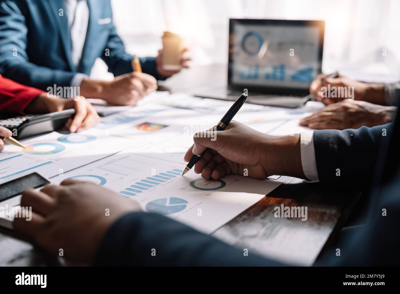 Finanzanalysten analysieren Finanzberichte eines Unternehmens zu einem Investitionsprojekt für die Papierplanung während einer Besprechung bei einer Unternehmensvorführung Stockfoto