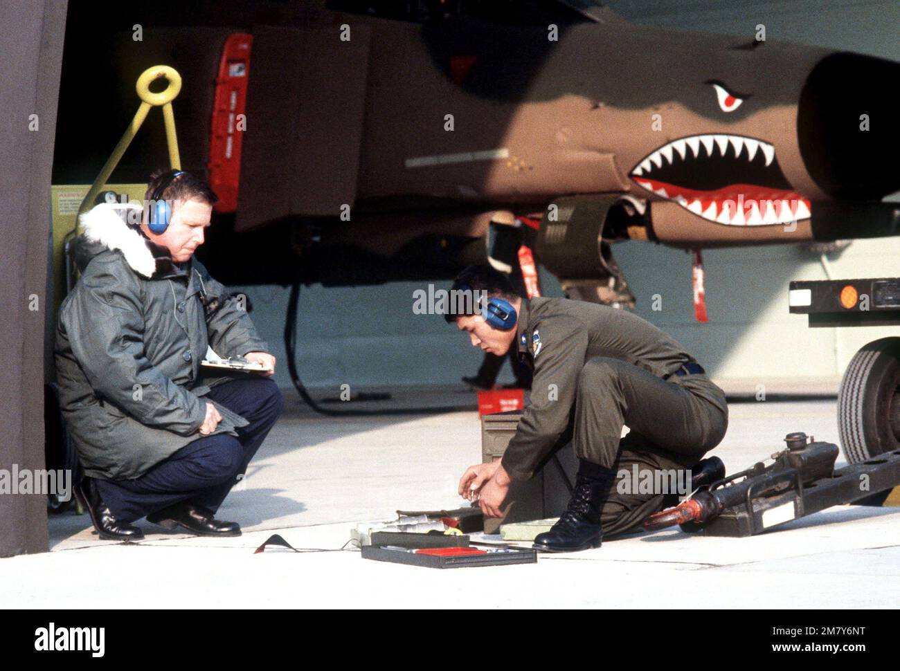 SMSGT Driscoll beobachtet, wie ein koreanisches Ladungsteam-Mitglied während des Munitionsladungswettbewerbs Sabre Spirit I eine Mark-84 2.000-Pfund-Bombe in einem F-4E Phantom II-Flugzeug vorbereitet Betreff Betrieb/Serie: Sabre SPIRIT I Base: Osan Air Base Land: Republik Korea (KOR) Stockfoto