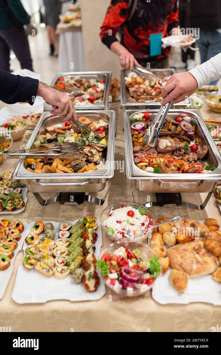 Hände aufnehmen Essen vom Buffet catering Tabelle auf der Party. Stockfoto