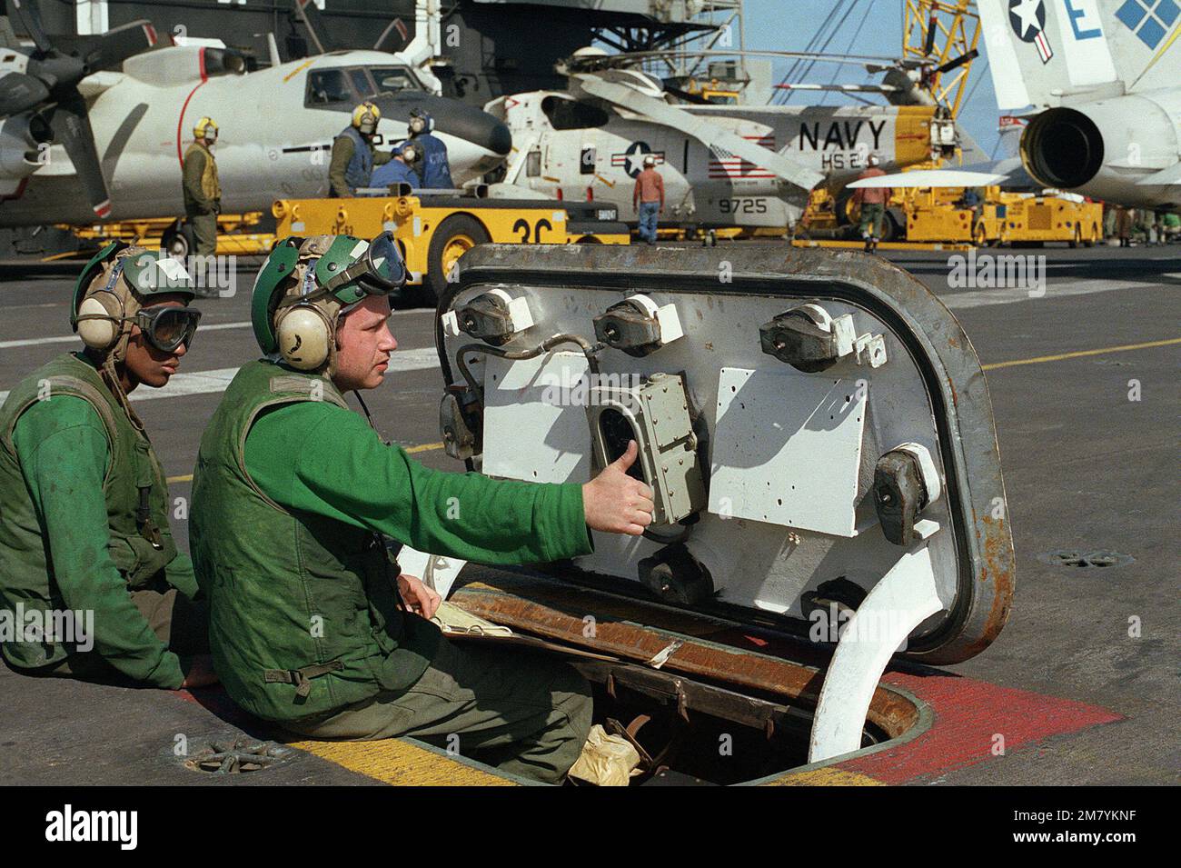 Katapult-Besatzungsmitglieder unterstützen den Start von Luftfahrzeugen vom Cockpit des Flugzeugträgers USS KITTY HAWK (CV 63). Basis: USS Kitty Hawk (CV 63) Stockfoto